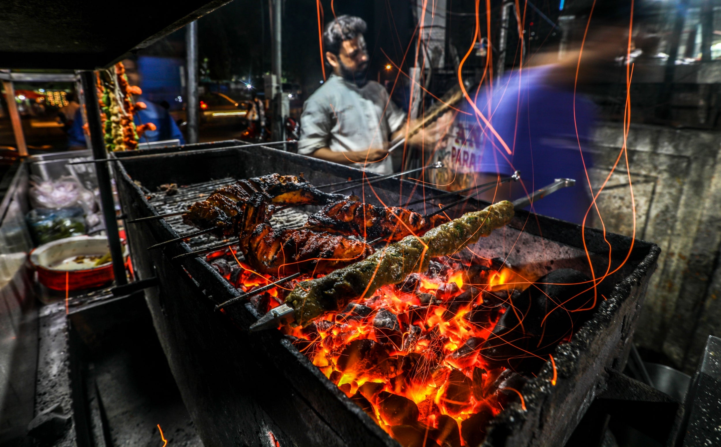 A vendor selling seekh kebabs and other non-vegetarian food on Mira Road, in the outskirts of Mumbai. Seekh kebabs are popular, especially among Muslim people. They are made of meat, most often mutton, lamb, beef or chicken, and served with various accompaniments. Kebabs are often cooked on a skewer over a fire like a grill or baked in an oven