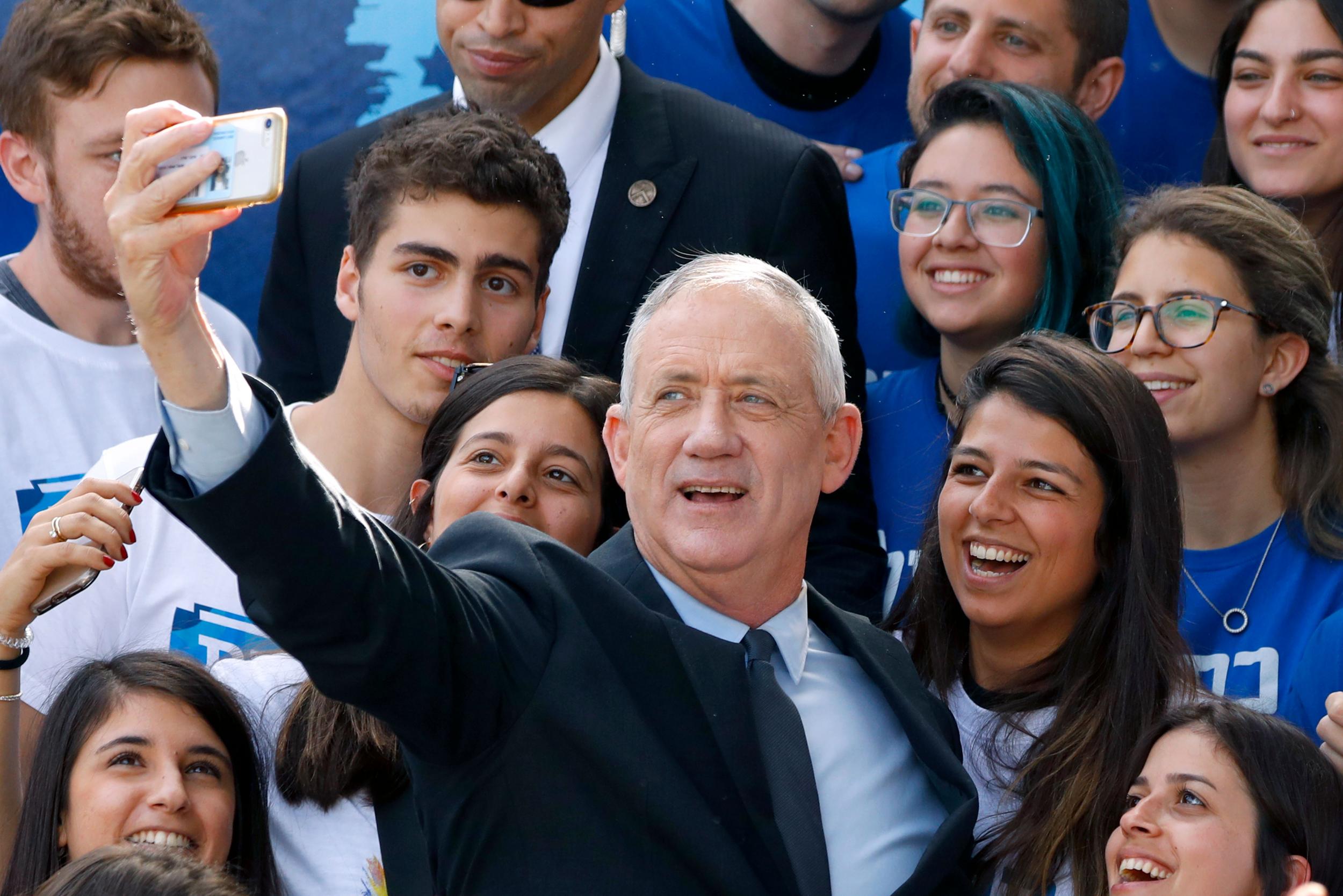 Retired Israeli general Benny Gantz, one of the leaders of the Blue and White political alliance, takes a picture with his supporters a day ahead of the electoral polls