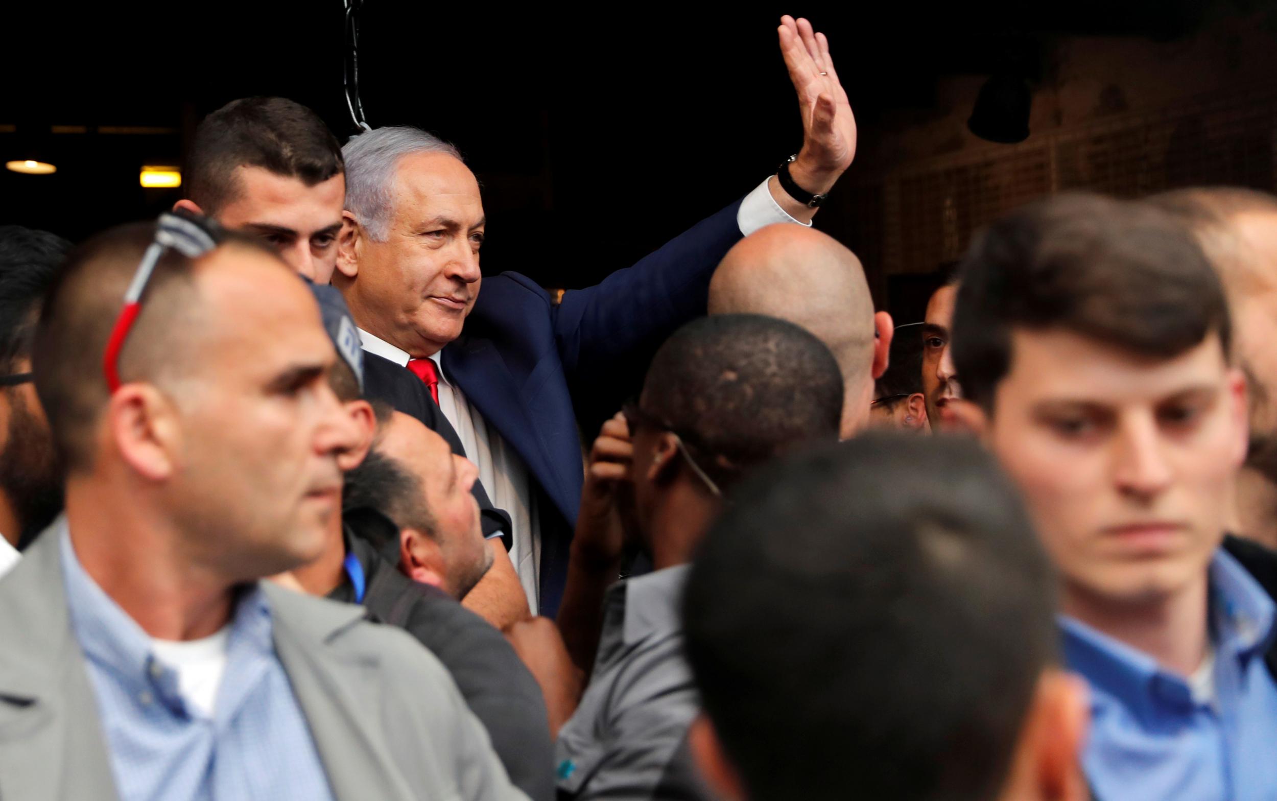 Israeli Prime Minister Benjamin Netanyahu waves as he visits Mahane Yehuda Market a day ahead of Israeli elections