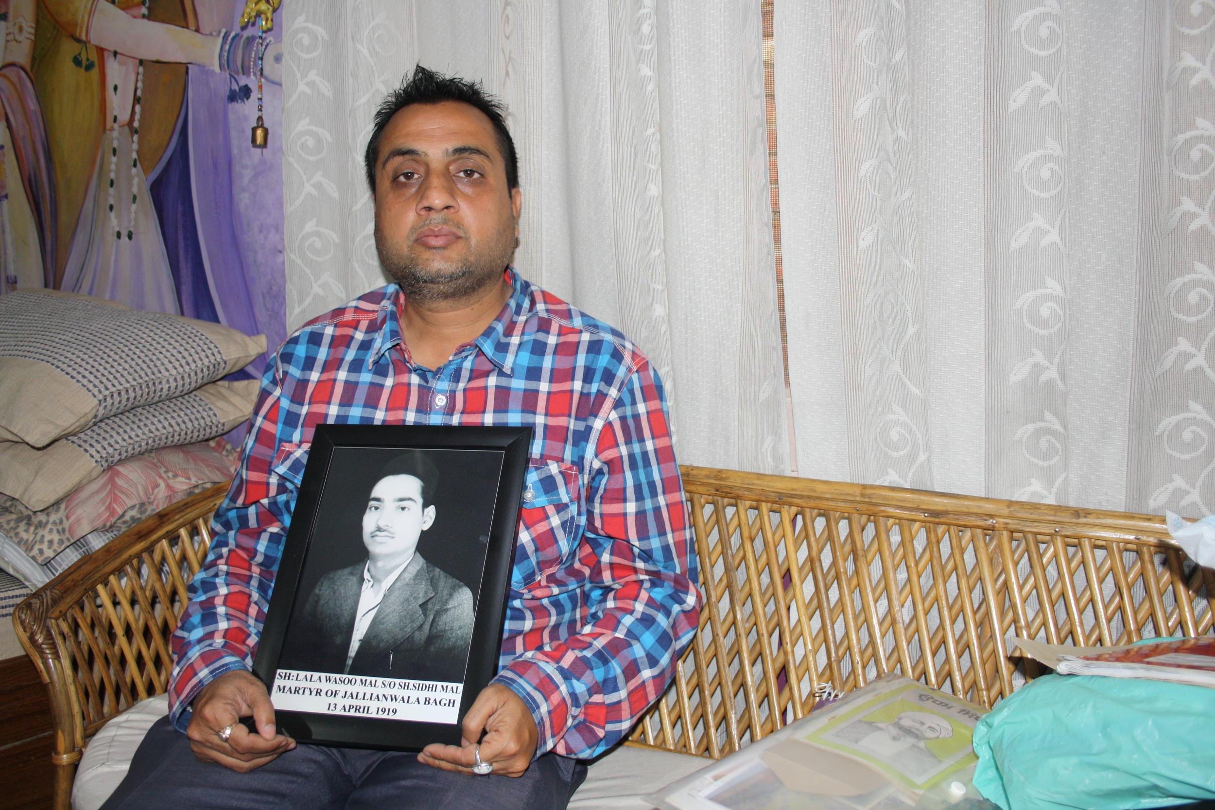 Sunil Kapoor holds a portrait of his great-grandfather Lala Wasoo Mal, who was killed at Jallianwala Bagh in 1919