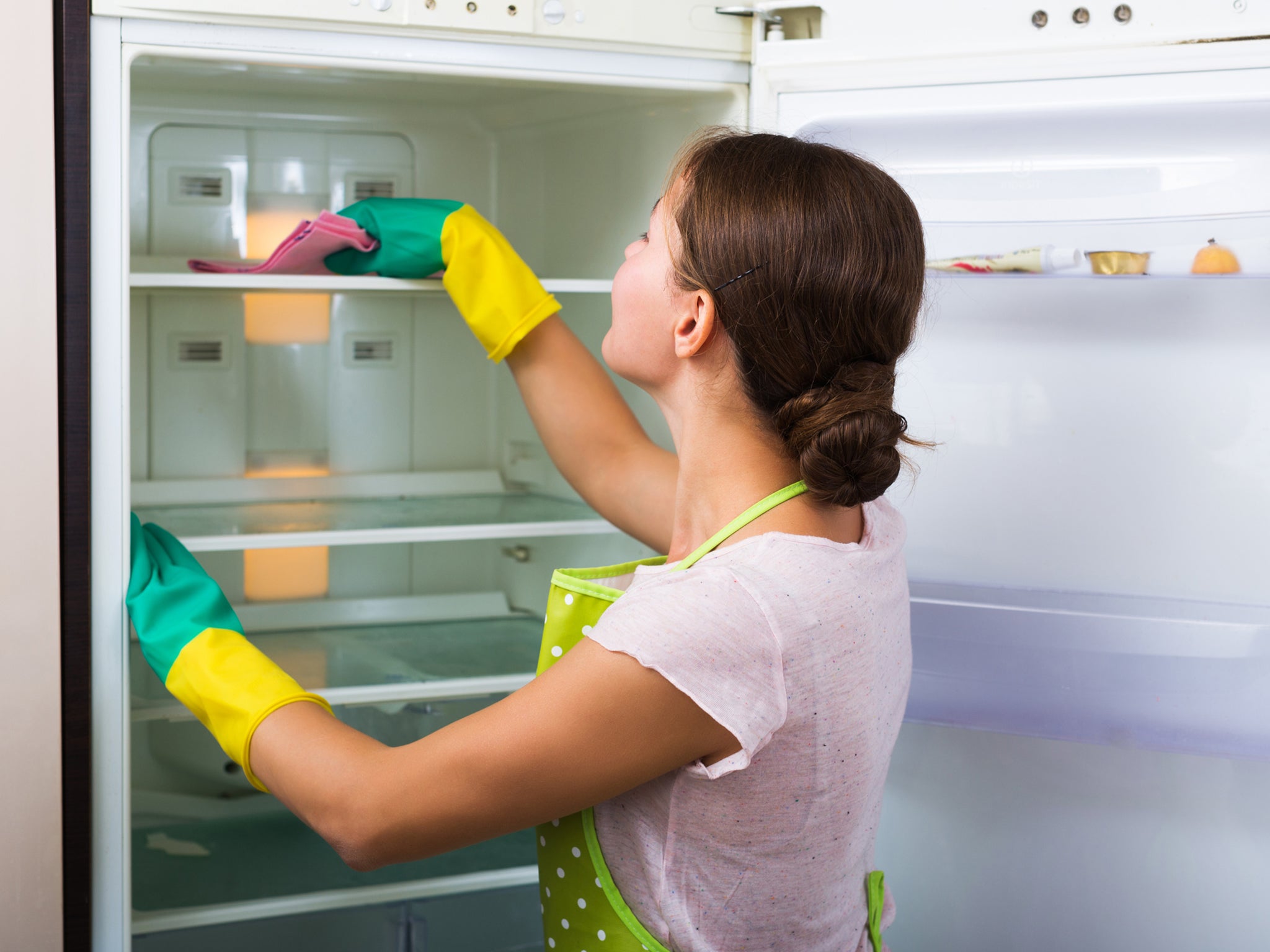 Wiping down refrigerator shelves should be part of a regular cleaning routine (Getty/iStock)