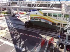 Video shows double-decker train smashing into car at level crossing