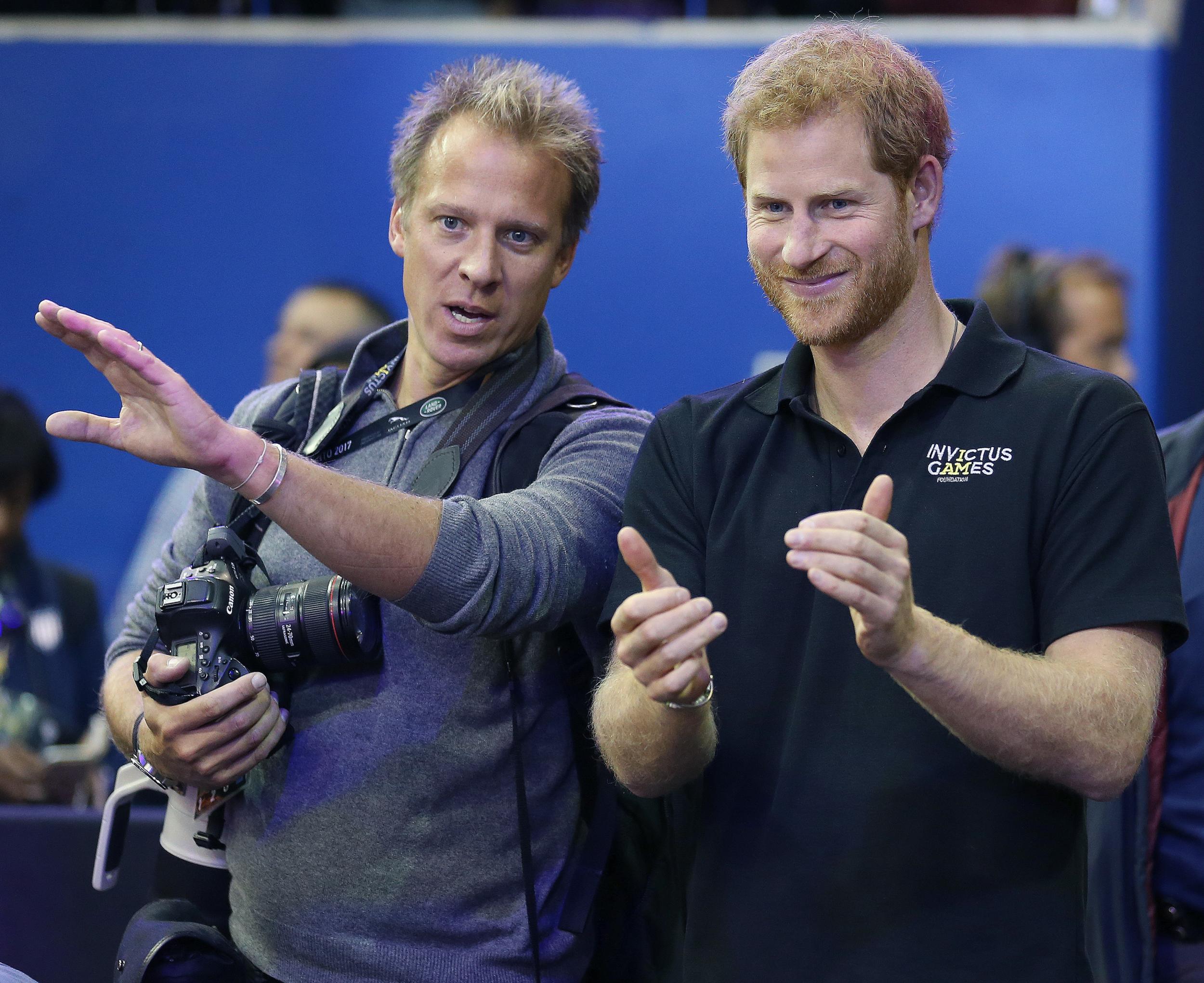 Royal photographer Chris Jackson goes over medal ceremony order with Prince Harry