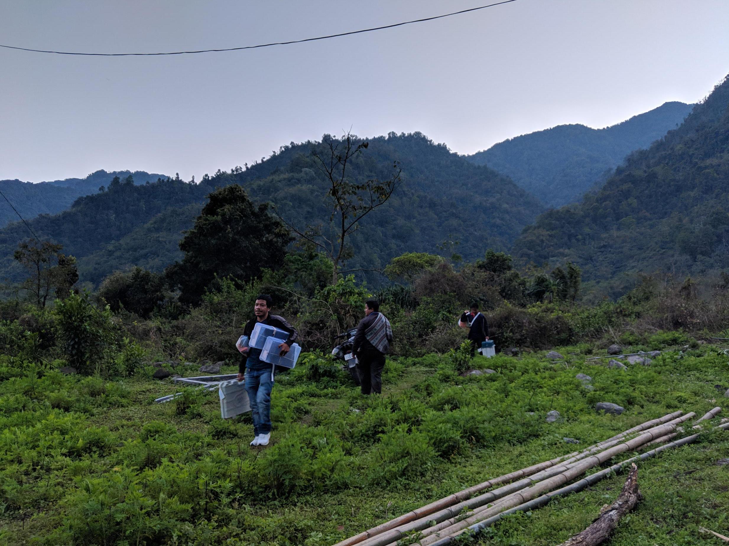 Gammar Bam and his team members carry their equipment after the poll closed at 5pm in Malogam