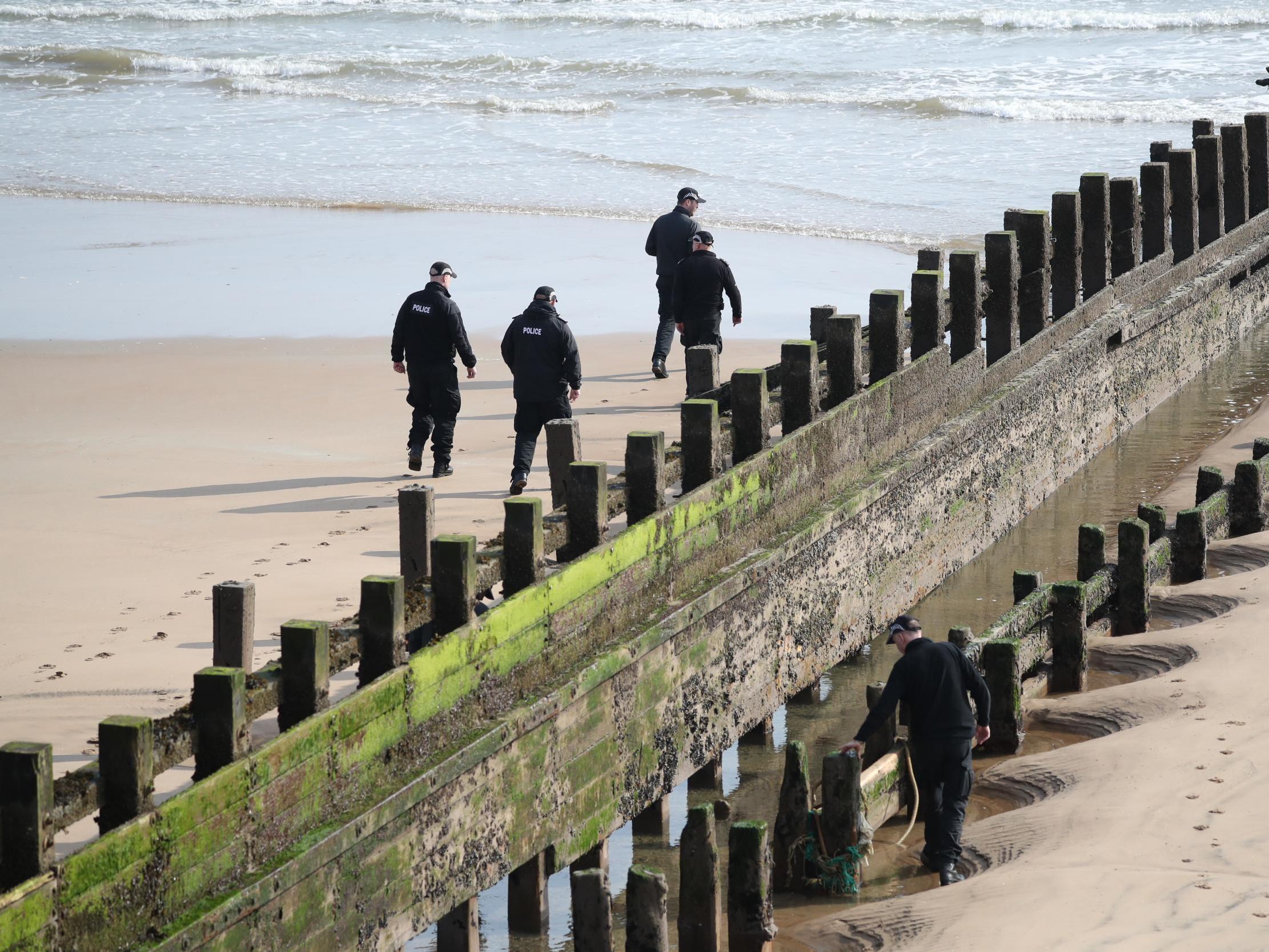 A police search team on the Aberdeen beach where they were rescued