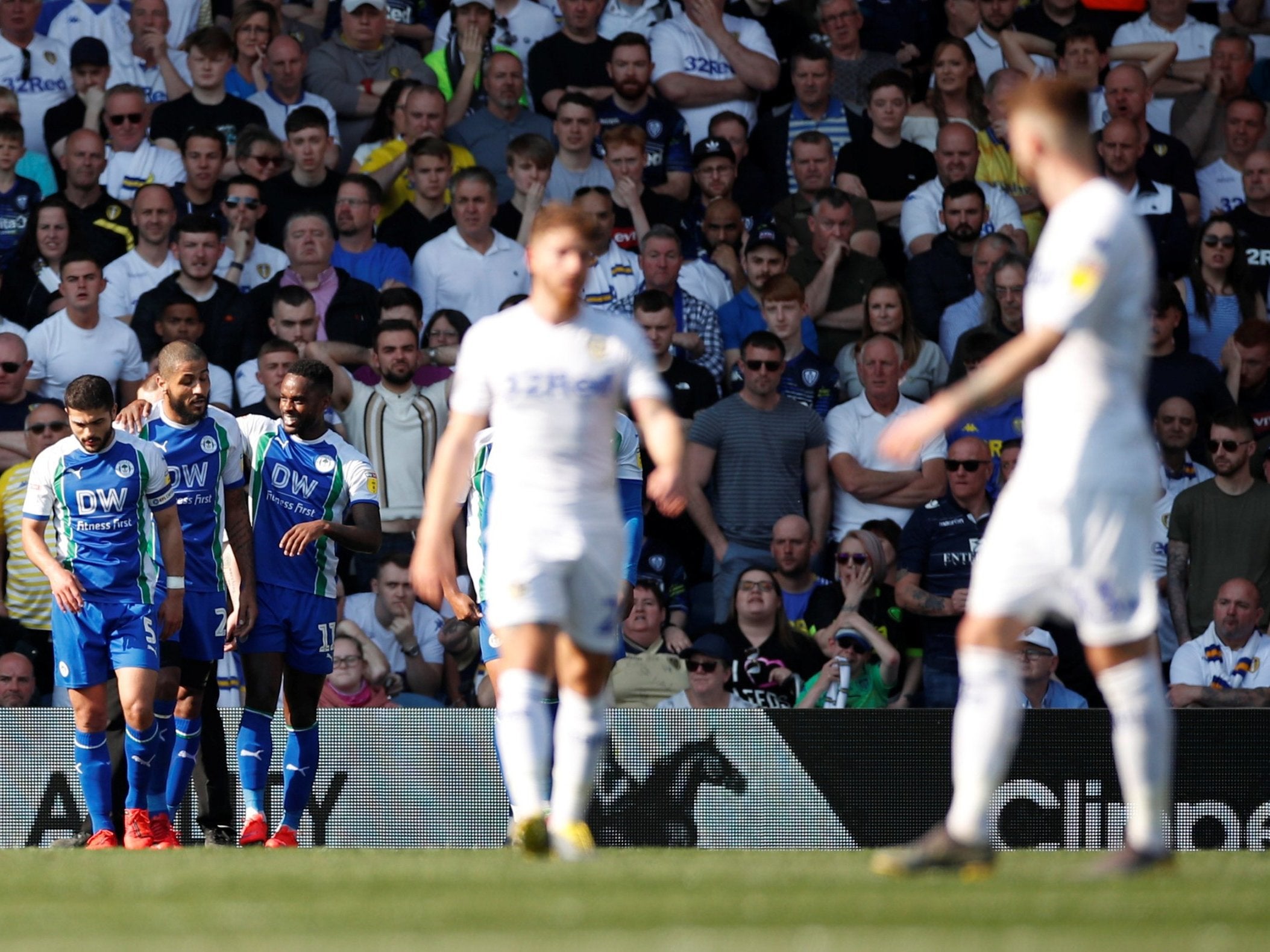 Leeds' players look on after Gavin Massey celebrates Wigan's second goal