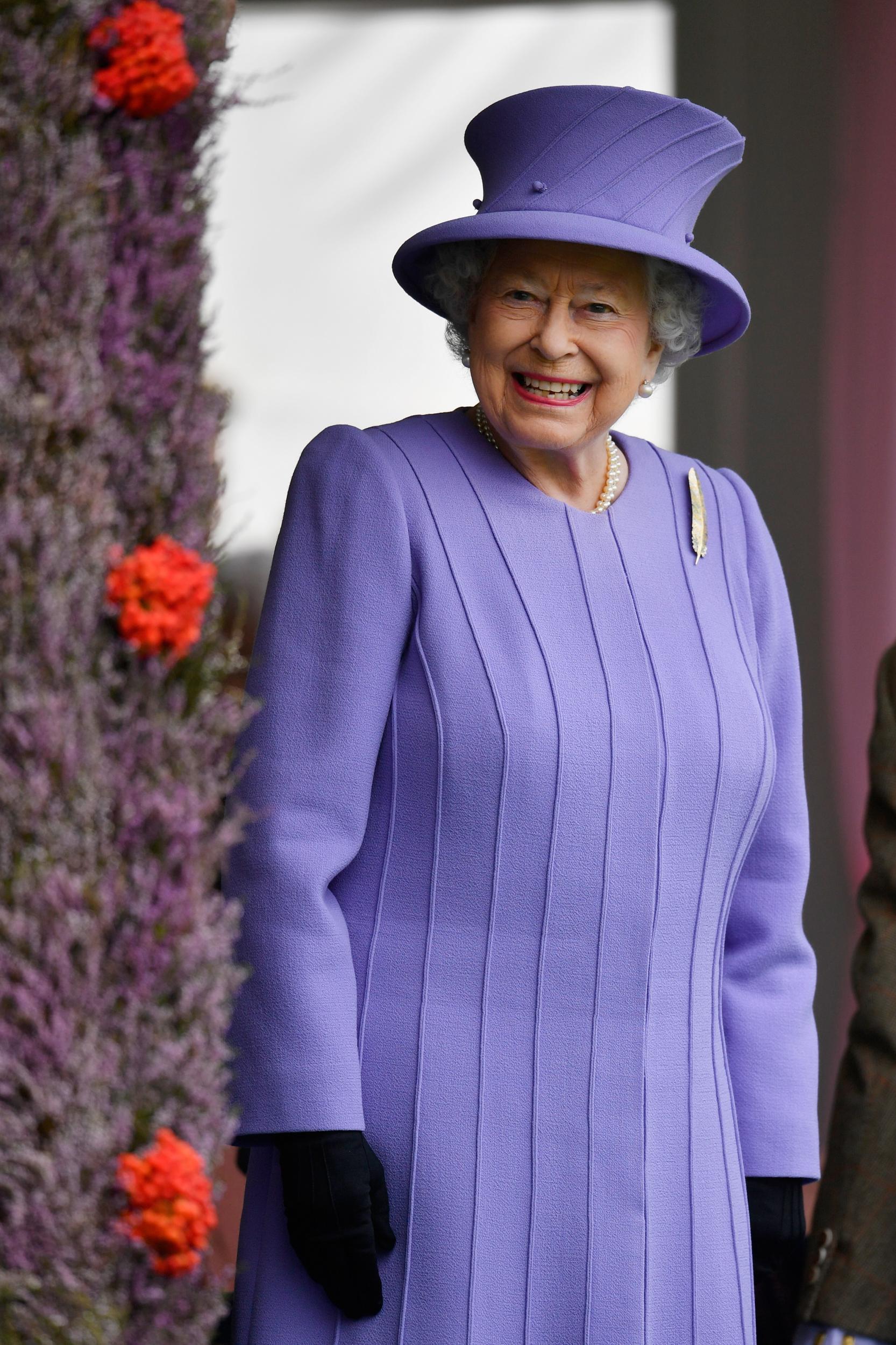 Queen Elizabeth II was all smiles as she attended the Braemar Gathering on 3 September 2016, wearing a purple ensemble adorned with vertical and diagonal line detailing.