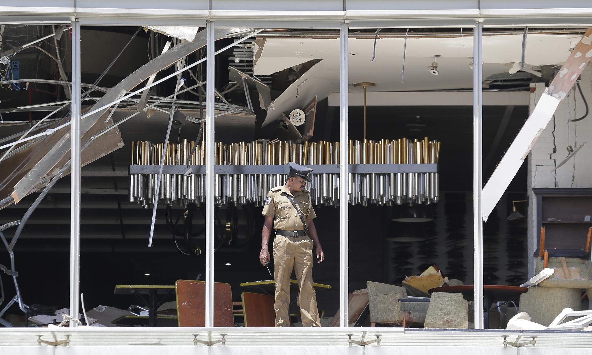 A police officer inspects the damage after a bombing at the Shangri-La Hotel in Sri Lankan capital Colombo