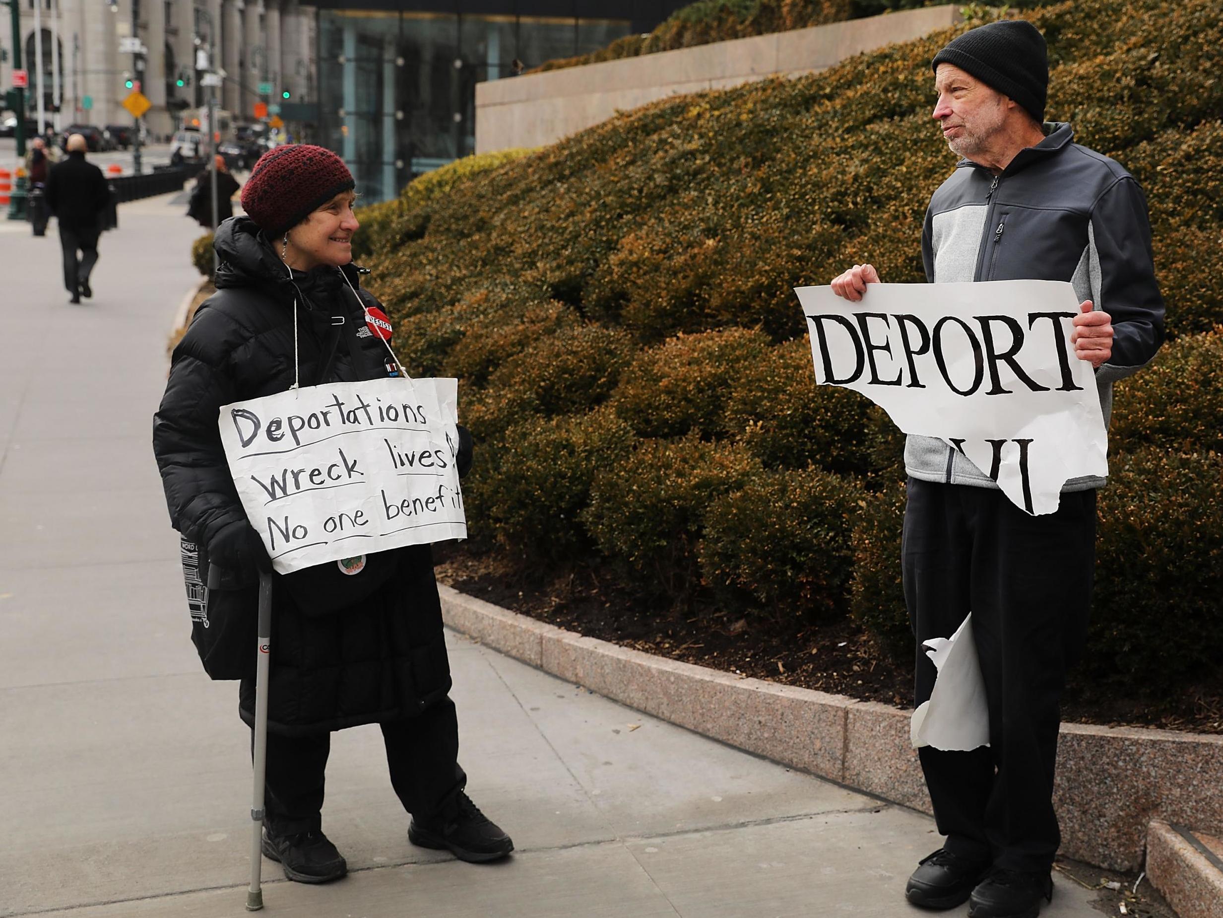 Pro Donald Trump protester (right) holds up sign calling for deportation in front of the Federal Building on 29 January 2018 New York City.