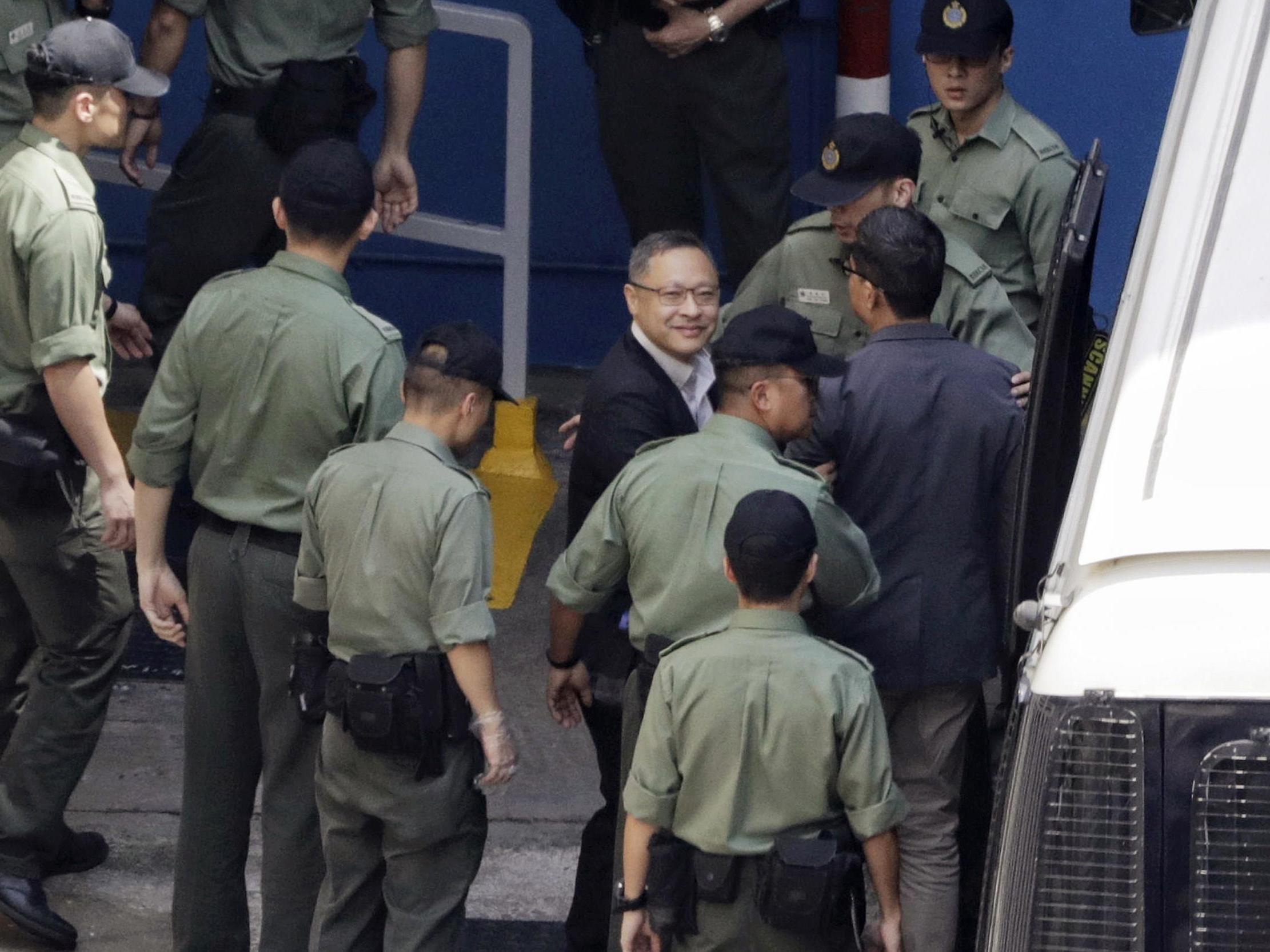 Occupy Central leaders Benny Tai, centre, and Chan Kin-man, right, are escorted by officers at a prison yard in Hong Kong