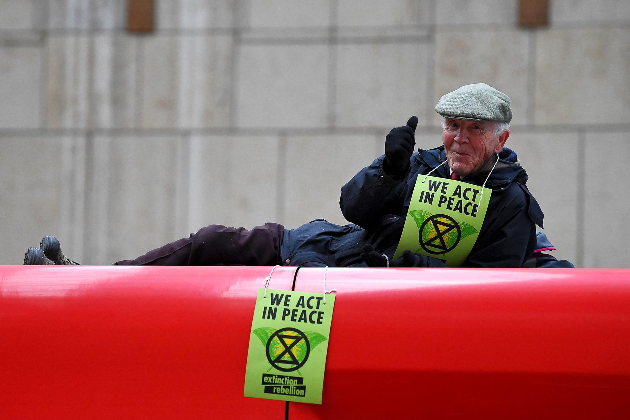 A protester gives a thumbs up as he stalls a DLR train at Canary Wharf station in London
