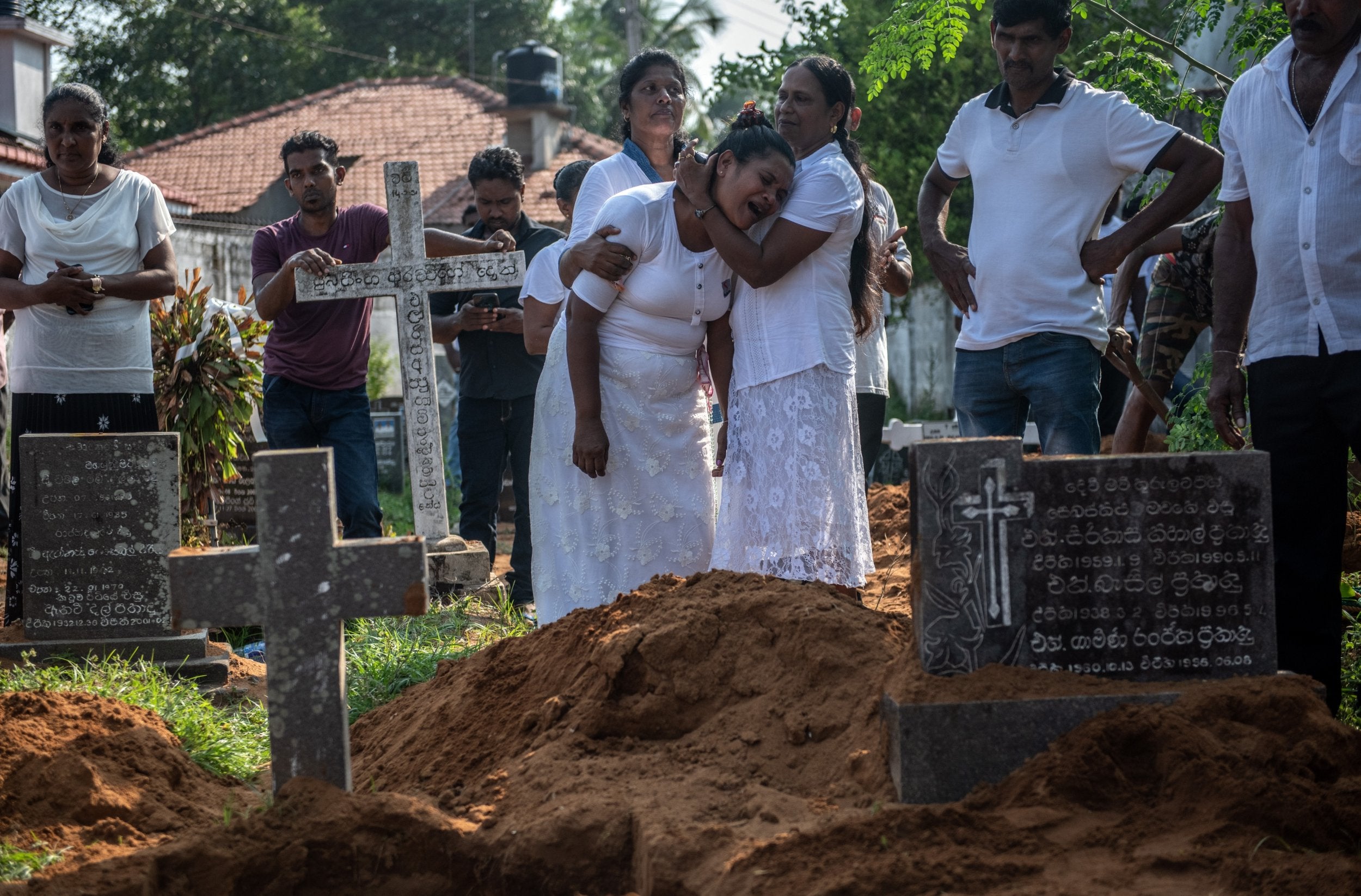 A woman is overcome with grief during a funeral for a person who was killed in the Easter Sunday attack on St Sebastian's Church