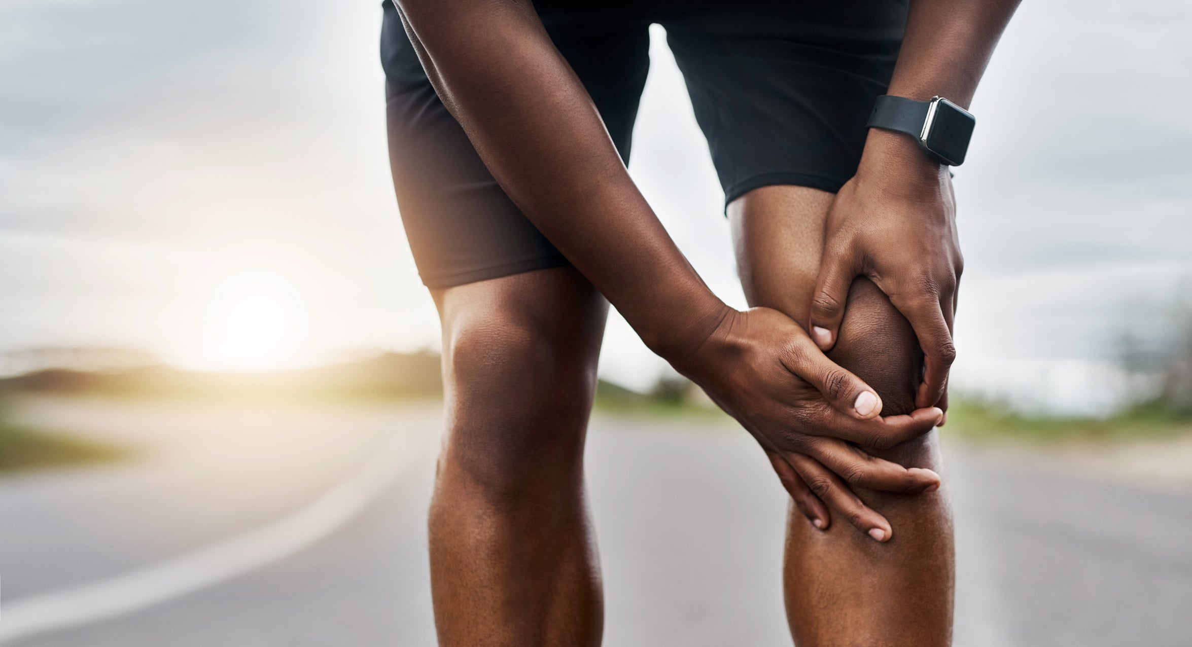 Man massages knee during race