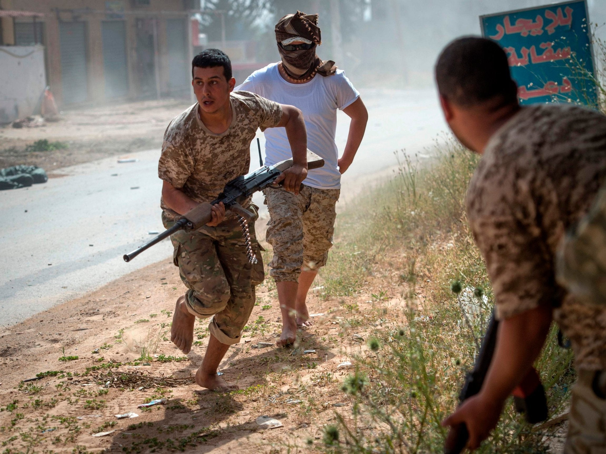 Fighters loyal to the government run for cover during clashes with Khalifa Haftar forces (AFP/Getty Images)