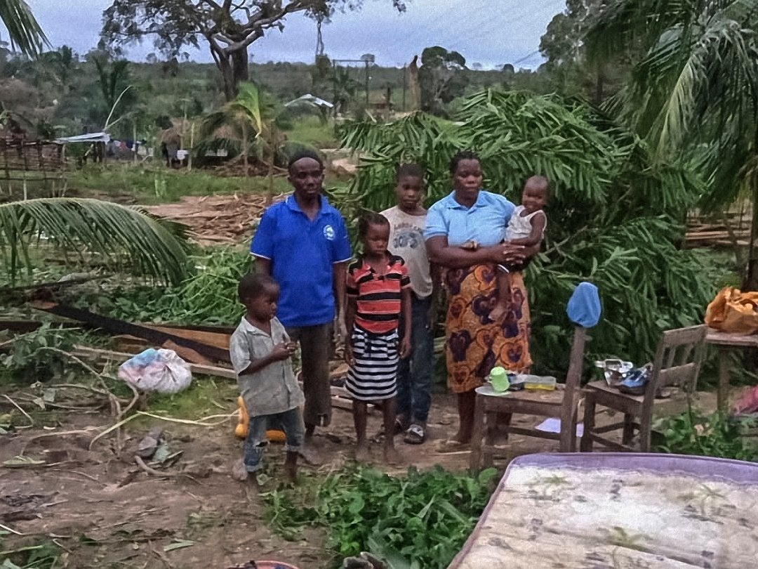 Maria Mendosa and Assan Madal with their children at the remains of their wrecked home