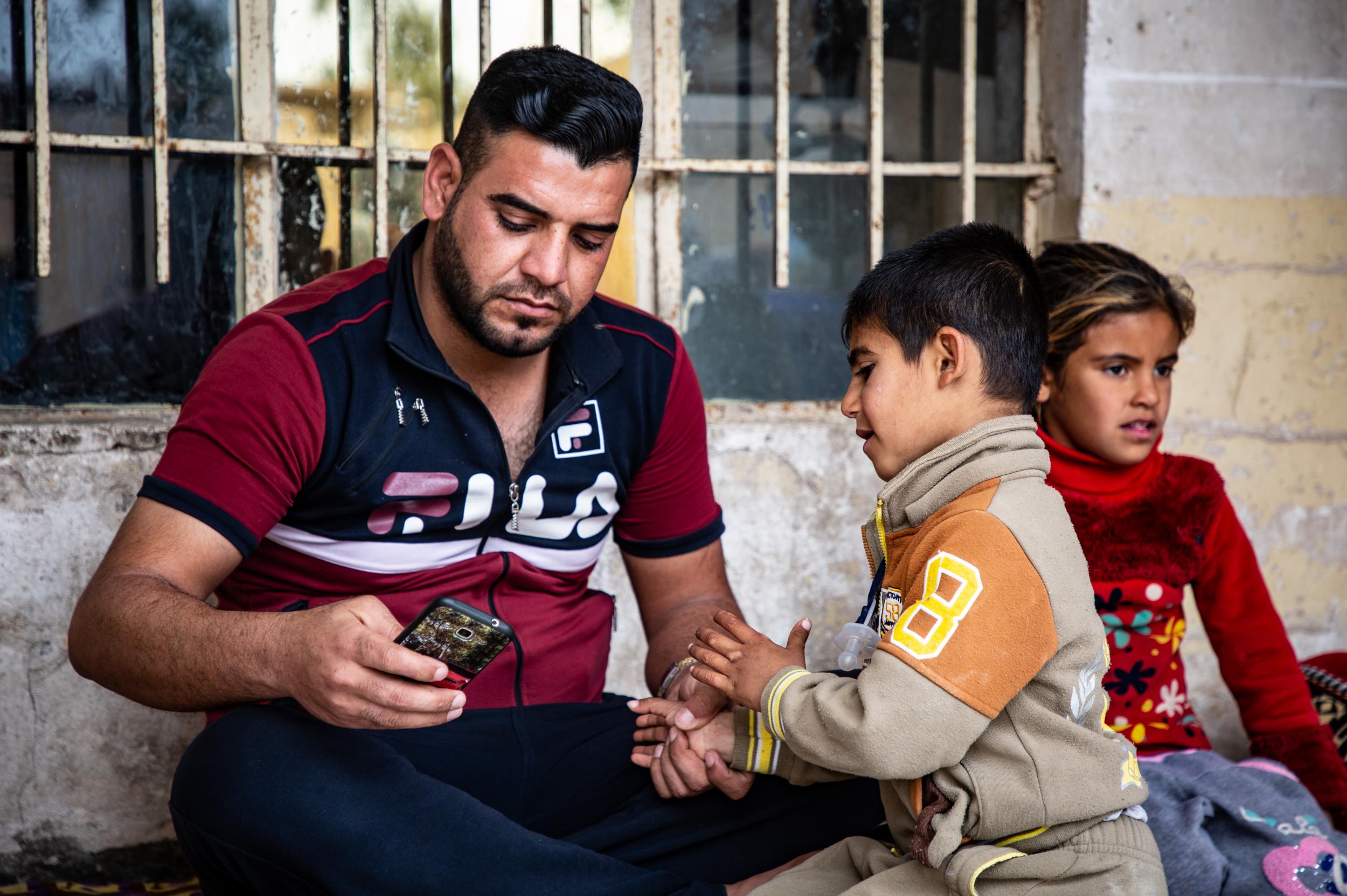 Ahmad and his disabled son, Mithaq who is barred access to medical care in Hawija