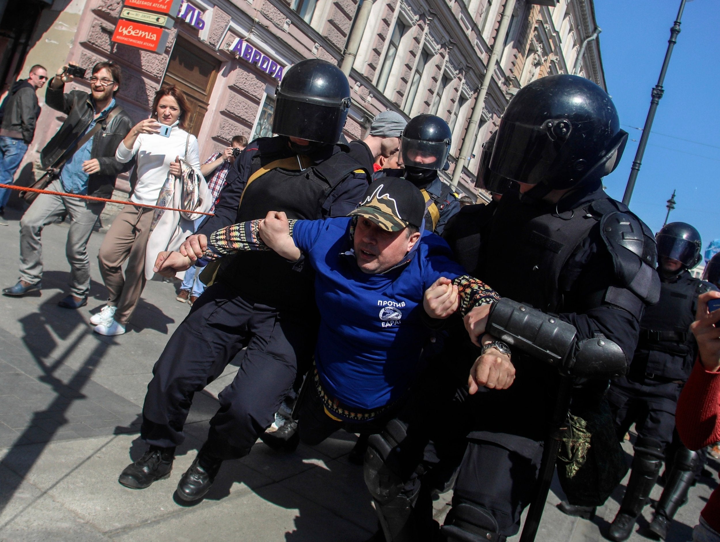 Riot police officers detain protesters during a rally in St Petersburg