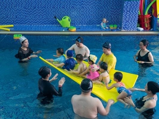 Zhou Jing, far left, attends a swimming class with son (The Washington Post)