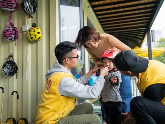 Zhou Jing and two bike coaches check protection devices worn by Xiao Kaixi (The Washington Post)