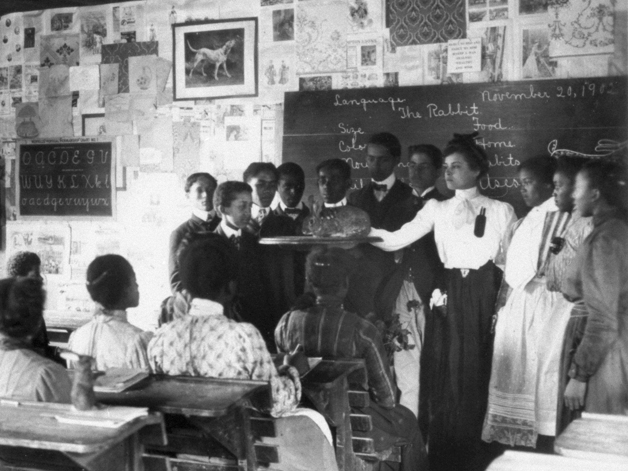 A woman wears a teaching pinafore to teach a science class at Tuskegee Institute in 1902