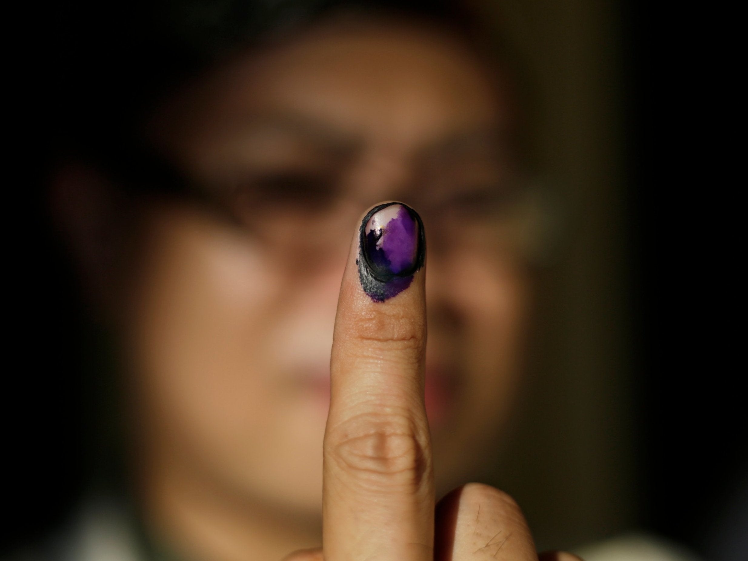 A Filipino displays her finger marked with indelible ink after voting at an elementary school turned into a voting precinct in Manila, Philippines, 13 May 2019.