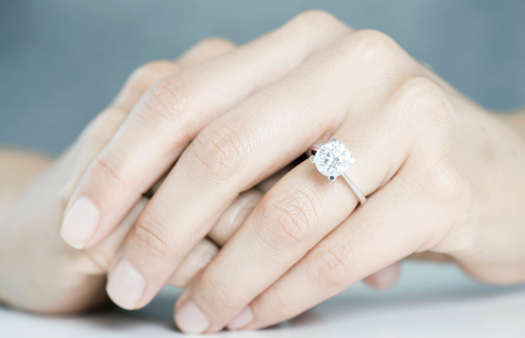 Diamond engagement ring on hands.