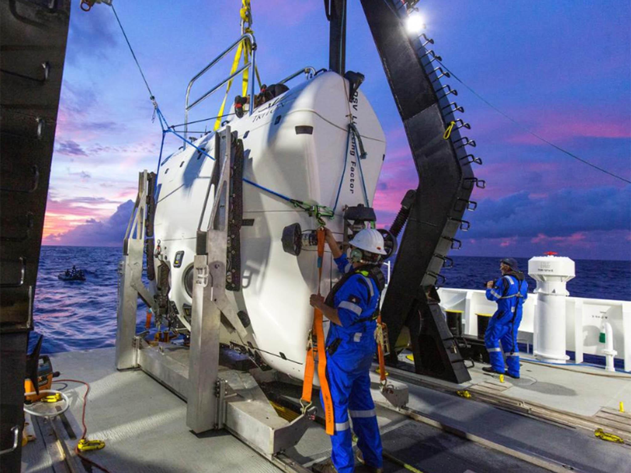 Technicians prepare part of the submarine before its Pacific voyage