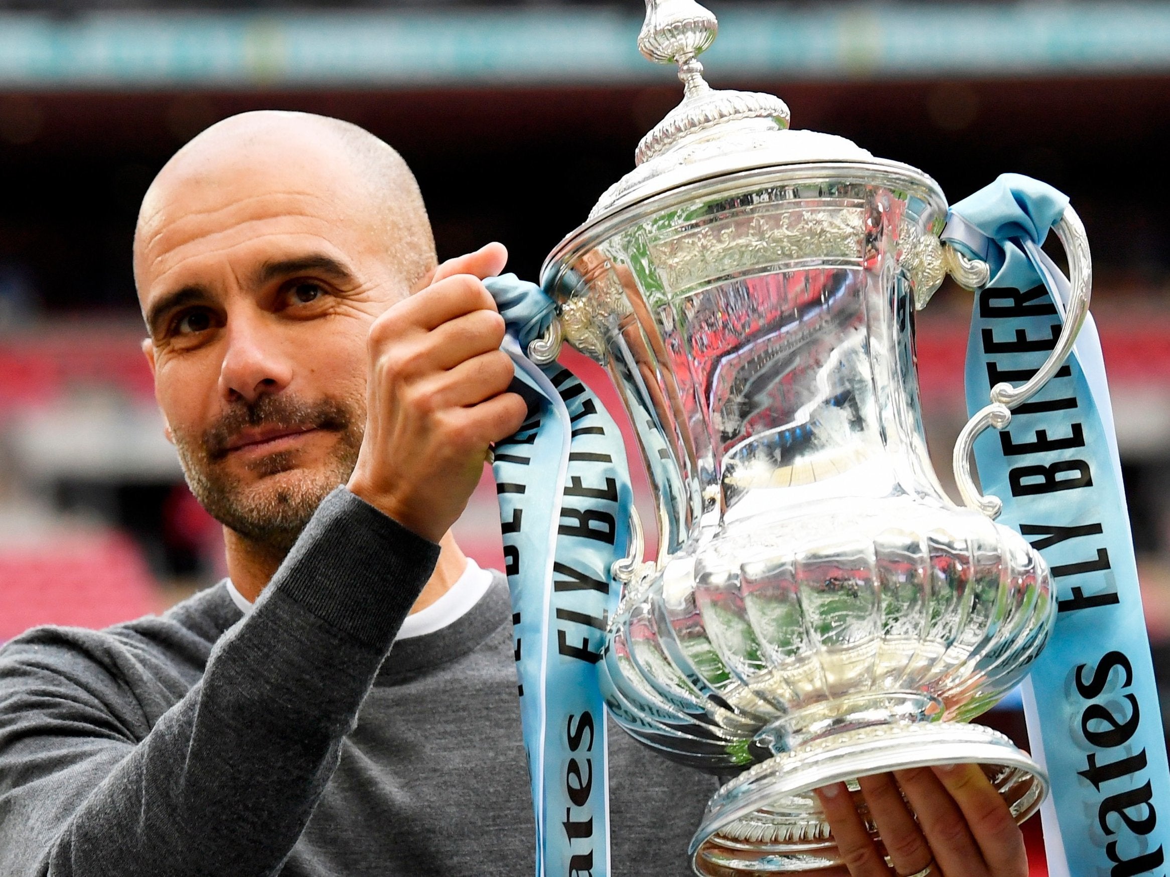 Pep Guardiola celebrates with the FA Cup trophy
