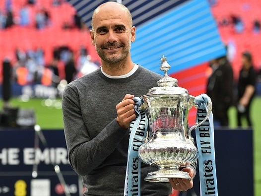 Pep Guardiola poses with the FA Cup trophy