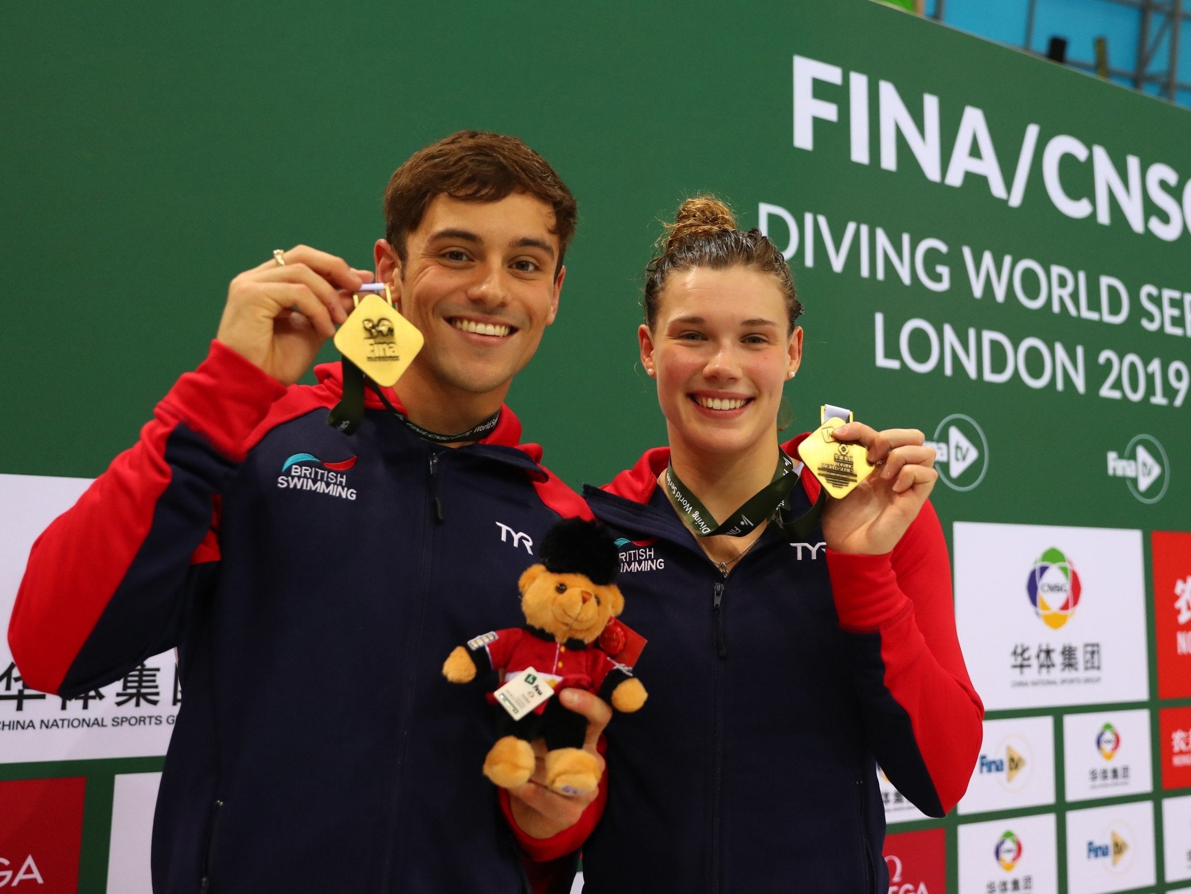 Tom Daley and Grace Reid pose with their gold medals after winning the Mixed 3m syncro final