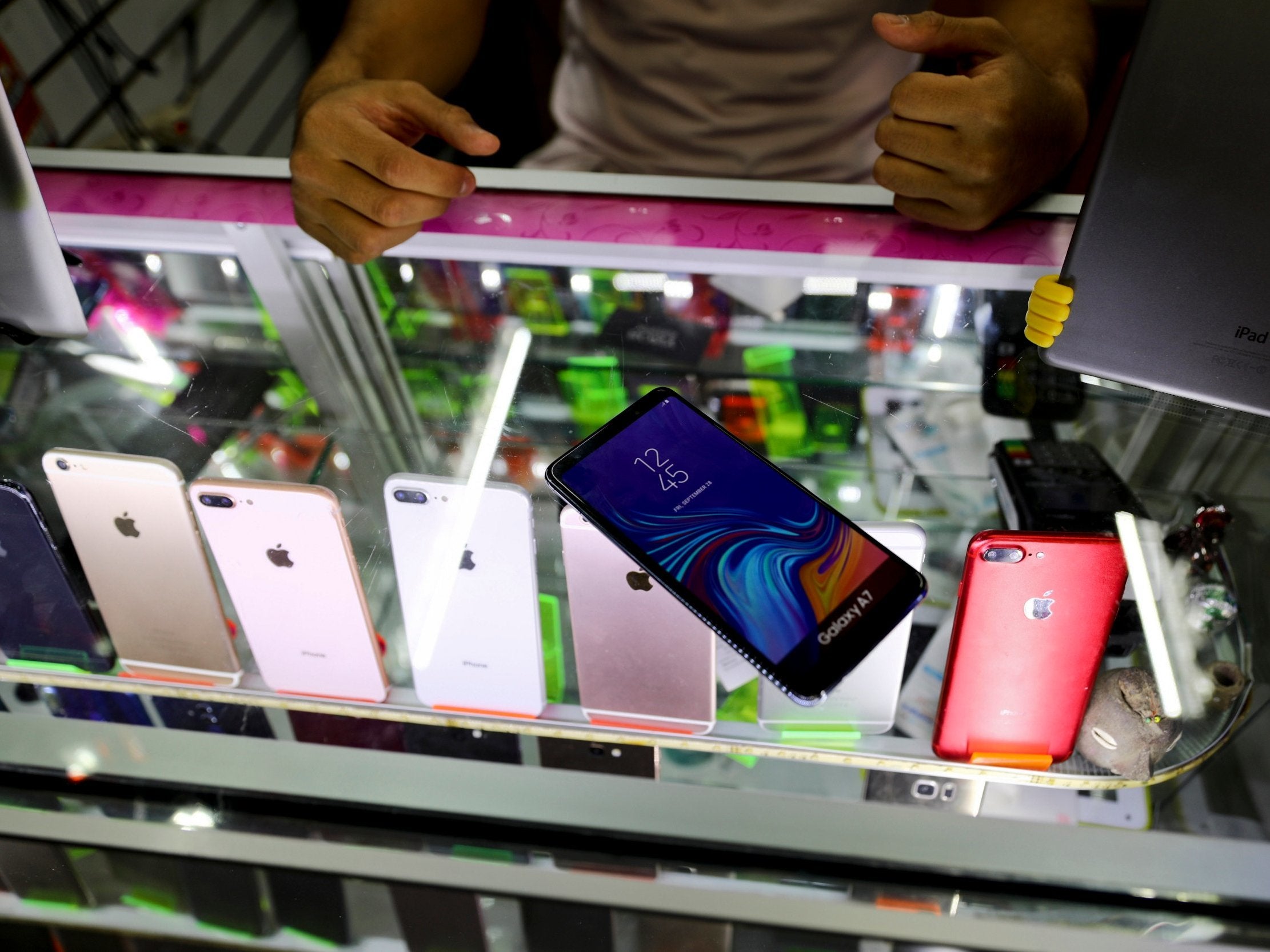 Axel, a vendor at an indoor electronics market, shows his dummy mobile phones which people buy in the case they are mugged and have to hand over their phones in Mexico City.