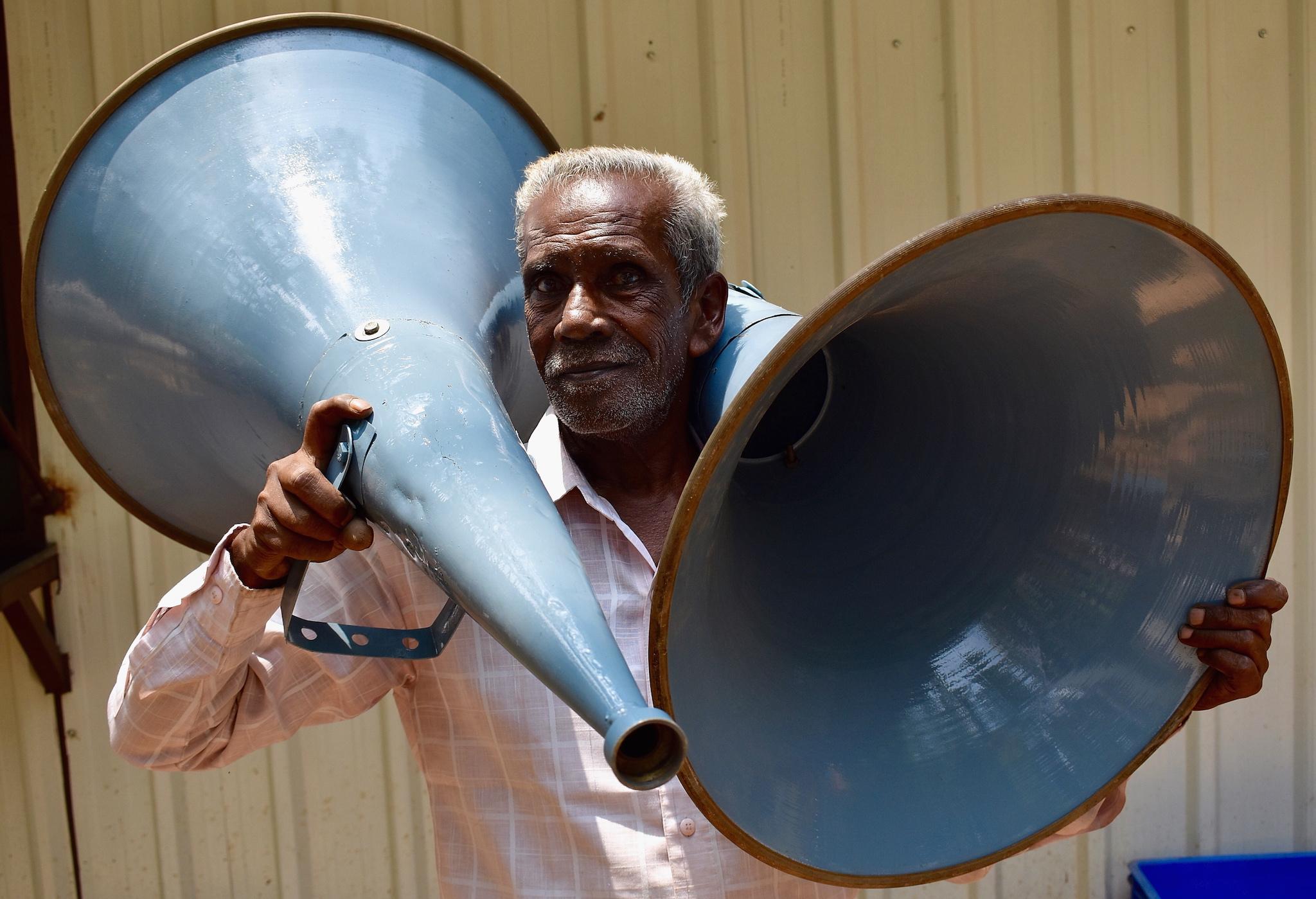 An Indian labourer carries the sound speakers ahead of preprations for the election vote counting process in Bangalore, India