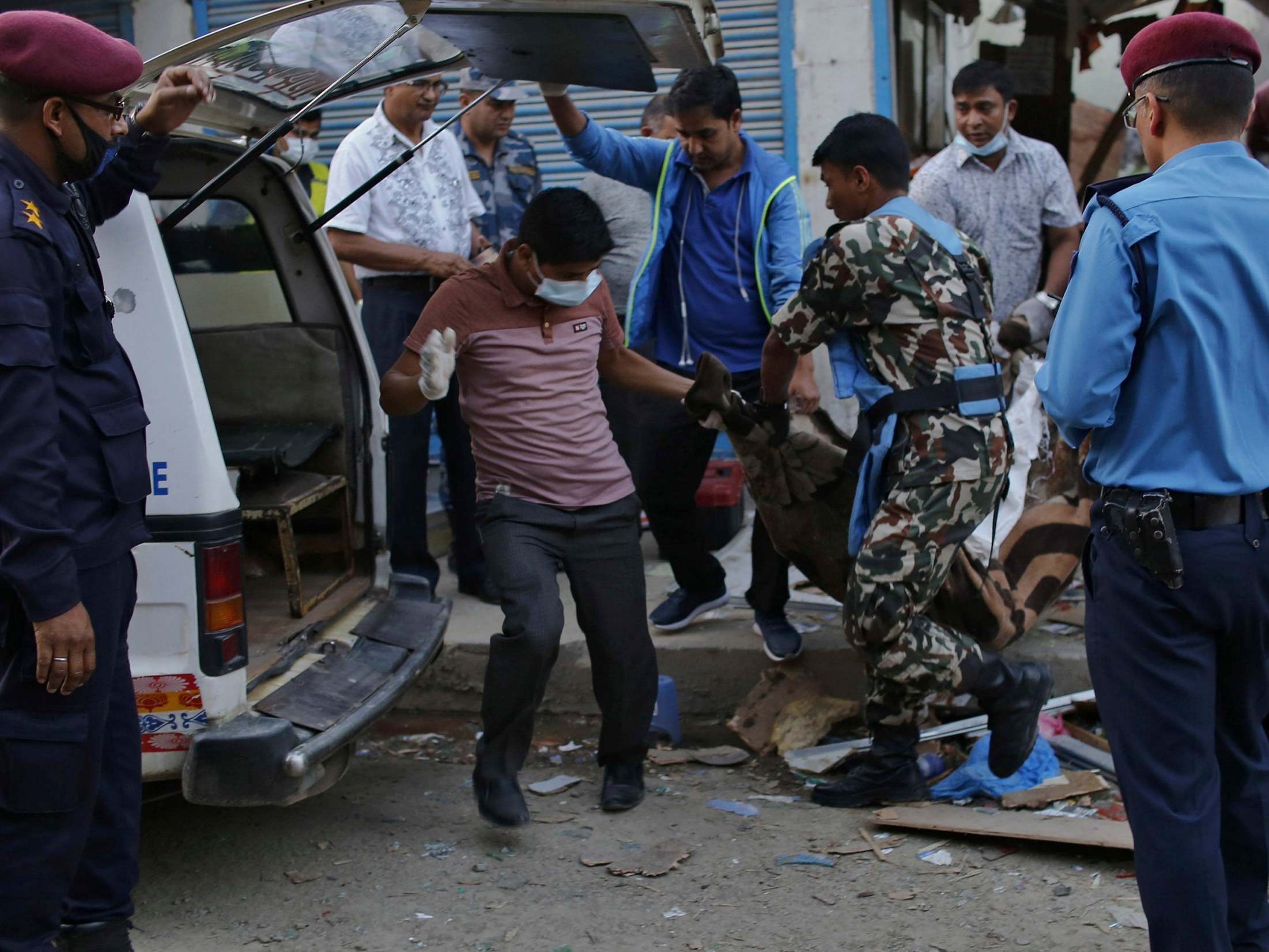 One of the victims of the explosions is removed from the scene in Kathmandu