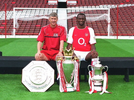 Patrick Vieira and Arsene Wenger pose with the Premier League and FA Cup trophy after a double winning season in 2002