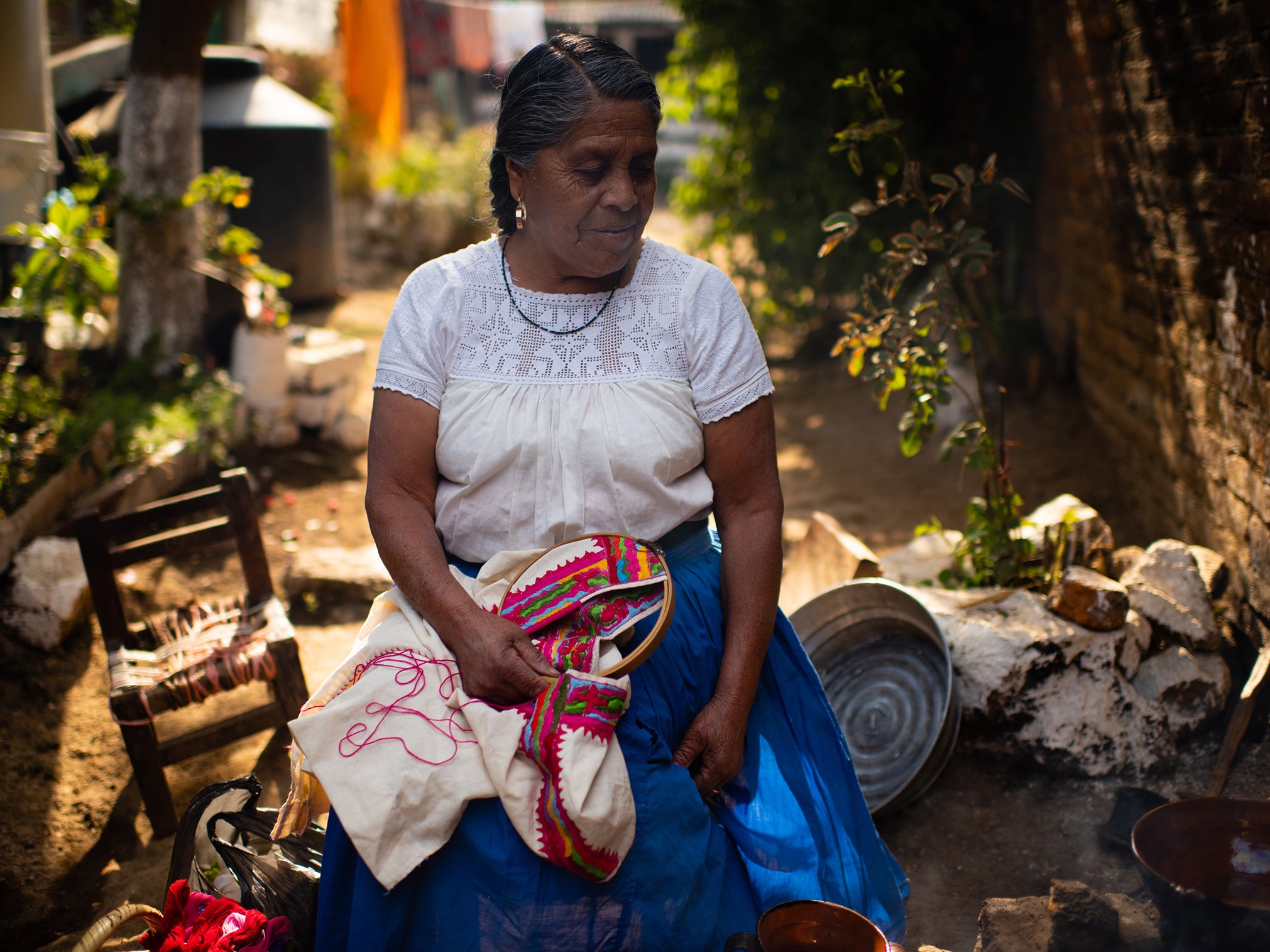 Maria Dominga Romero Leon sets aside her embroidery to cook lunch over a fire in her village of Cheran, Mexico