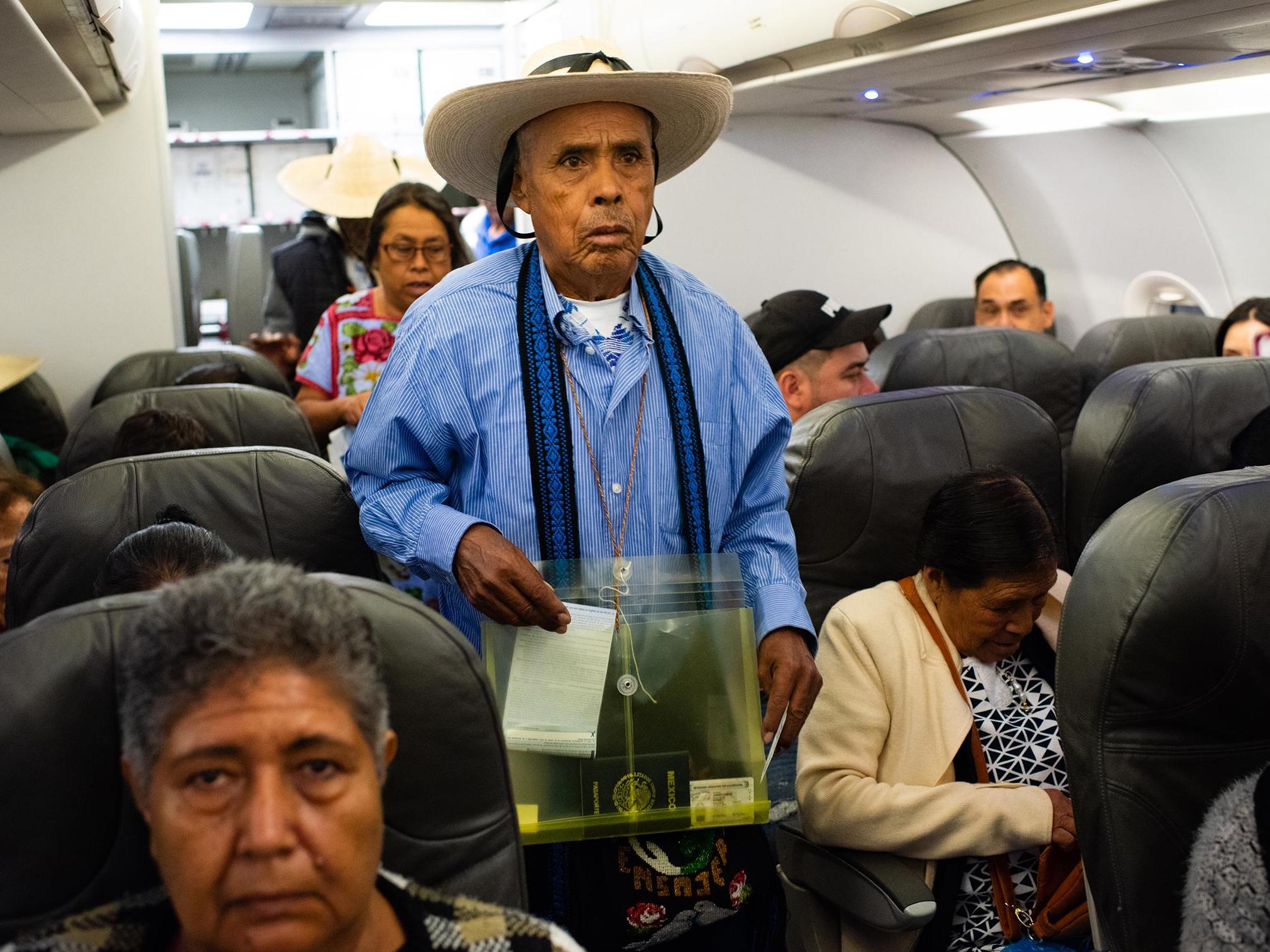 Eutimio Jasinto Campos, 78, of Cheranastico, looks for his seat on the plane: he hasn’t seen his son for 18 years