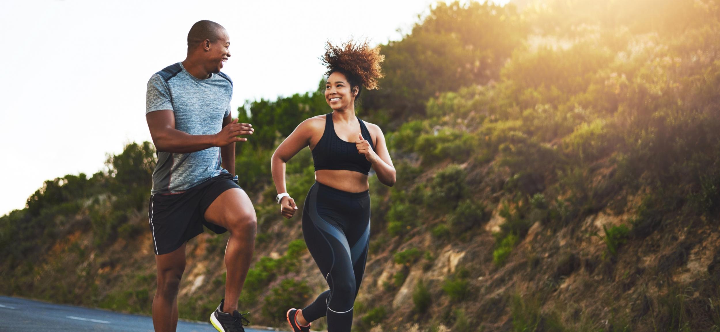 A couple running together in the sunshine