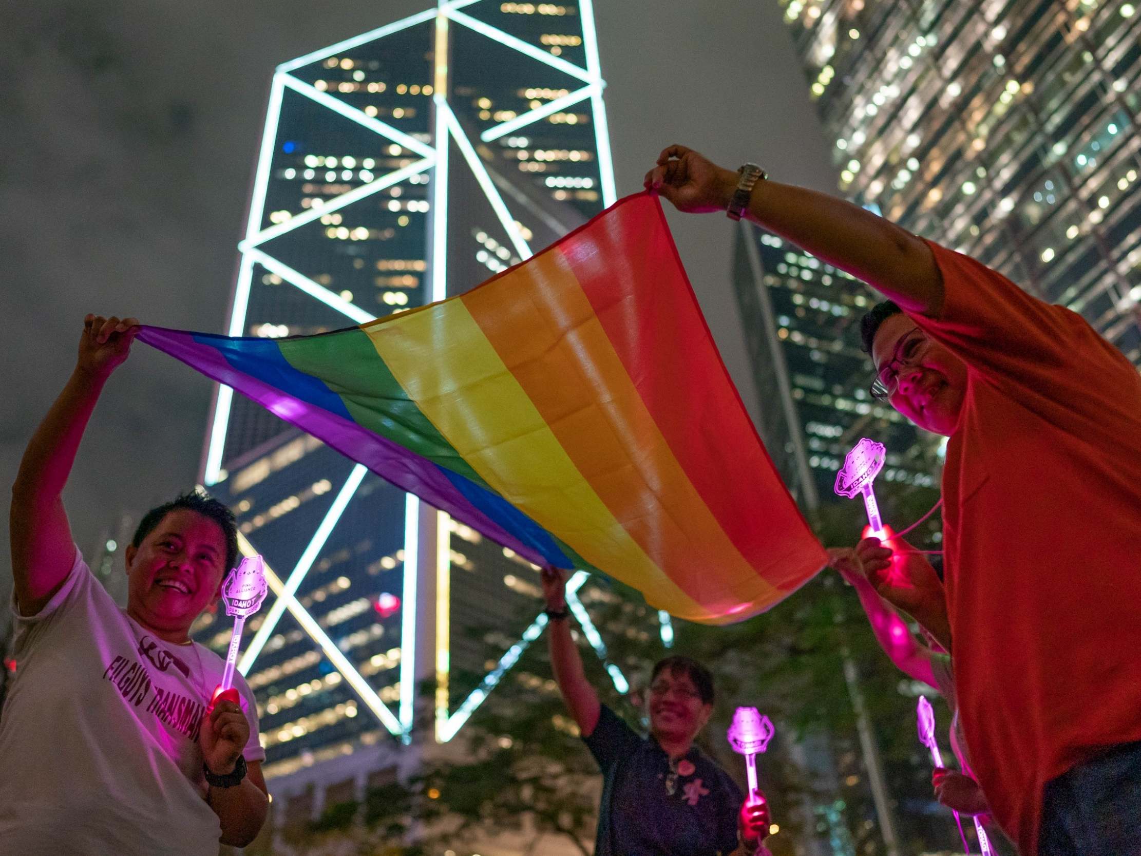 LGBT+ supporters hold a rainbow flag as they take part in a gathering for the 2019 International Day Against Homophobia in Hong Kong