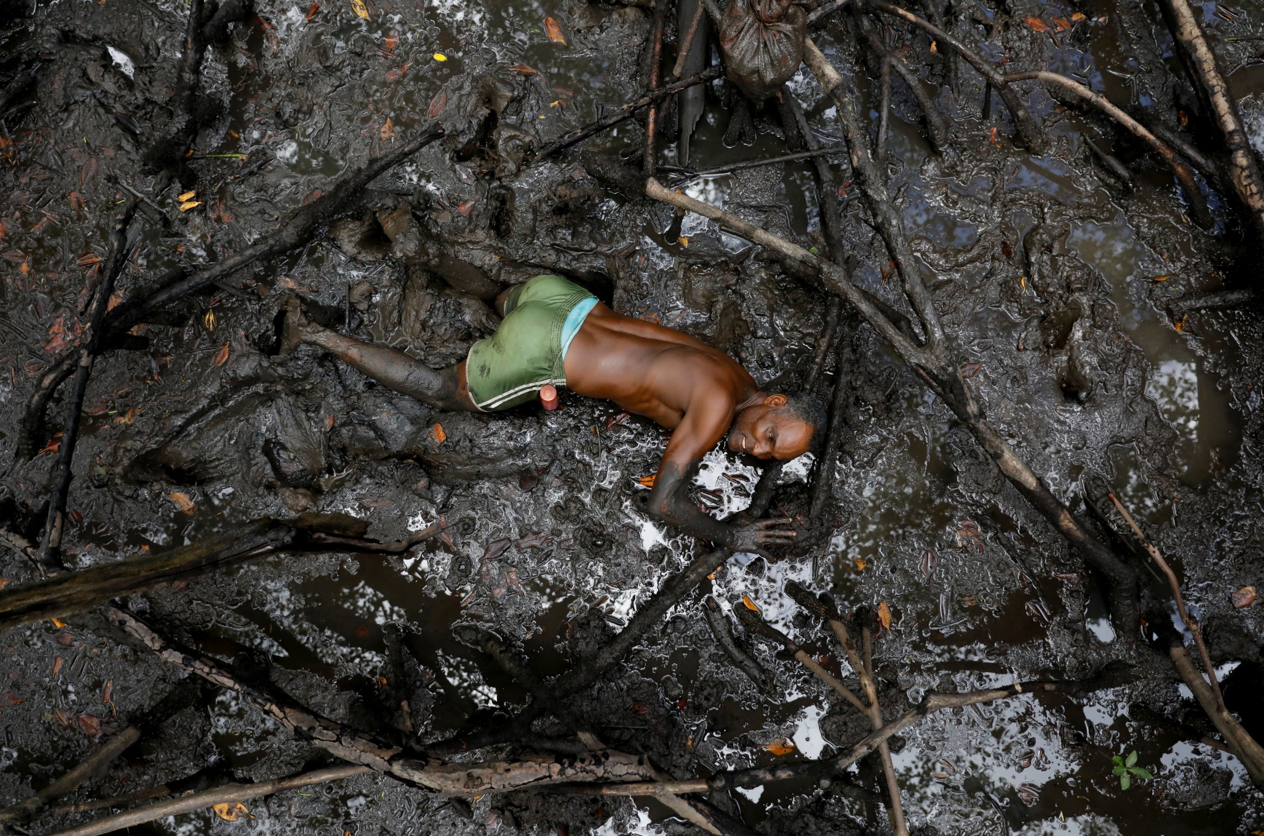 Jose da Cruz catches crabs inside a mangrove forest