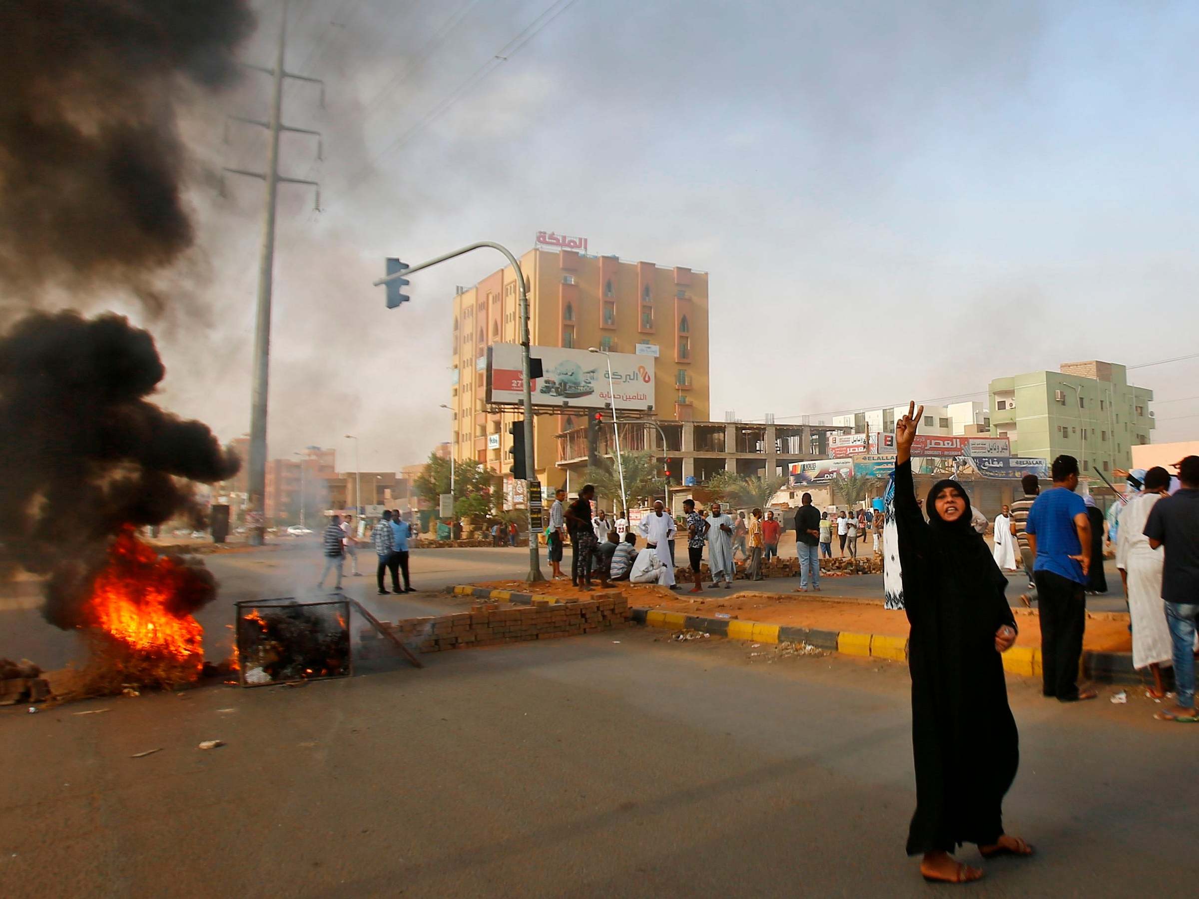 A Sudanese protester flashes the V sign for victory outside Khartoum’s army headquarters as the army tries to break up the sit-in