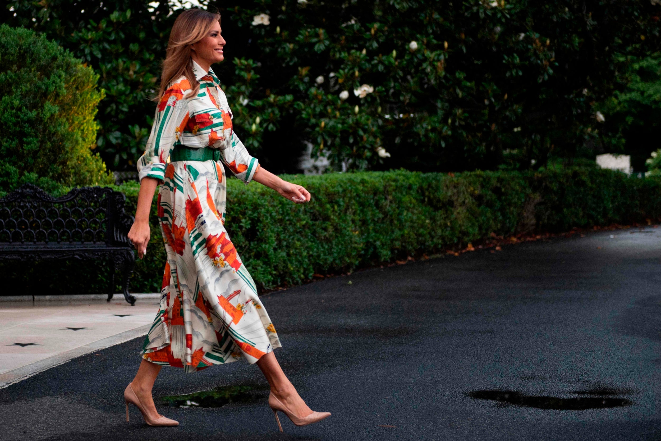 Melania wears a calf-skimming shirt dress by Gucci before departing the White House in Washington DC.