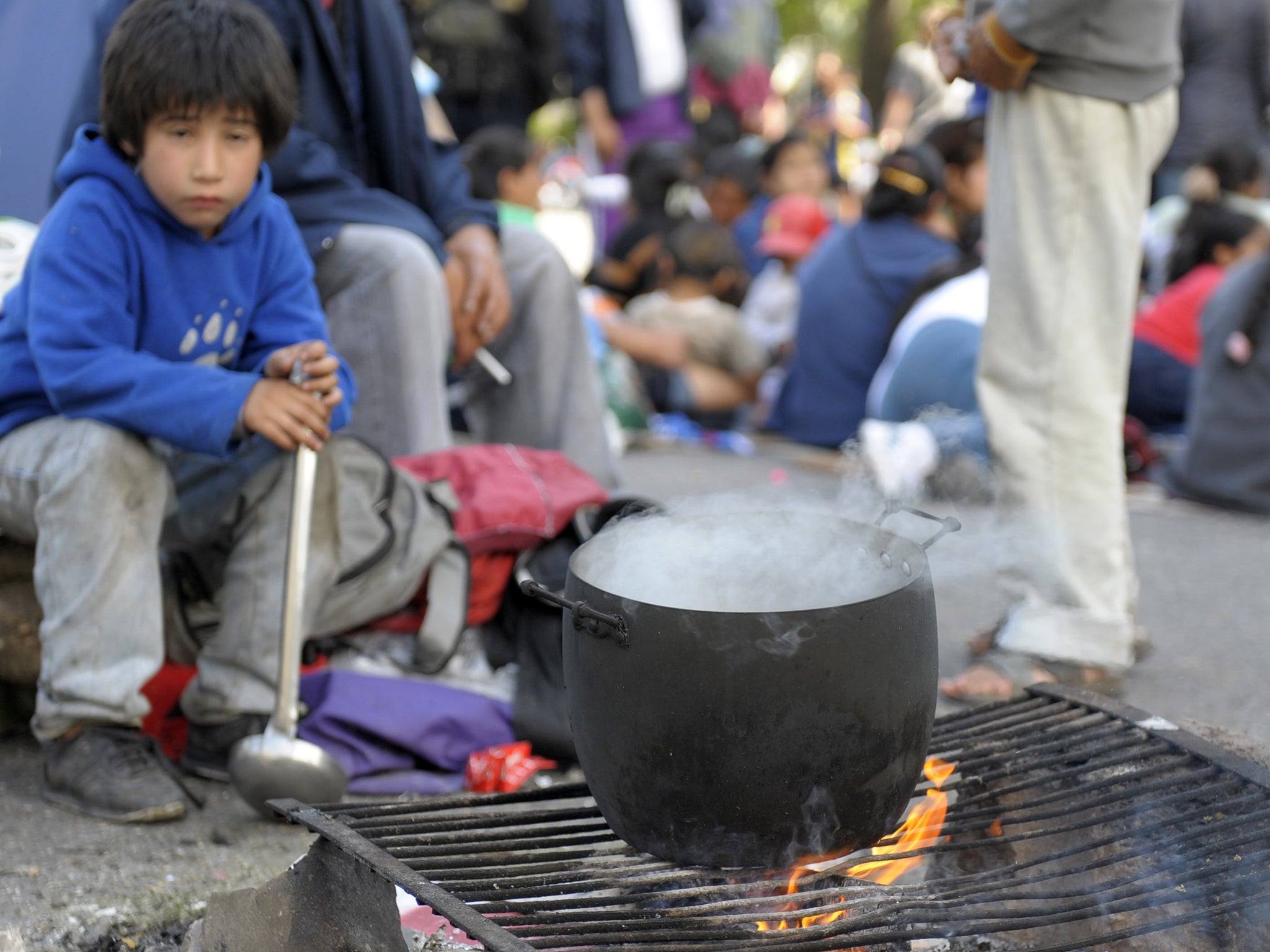 A boy boils a pot of water to brew mate (Getty)