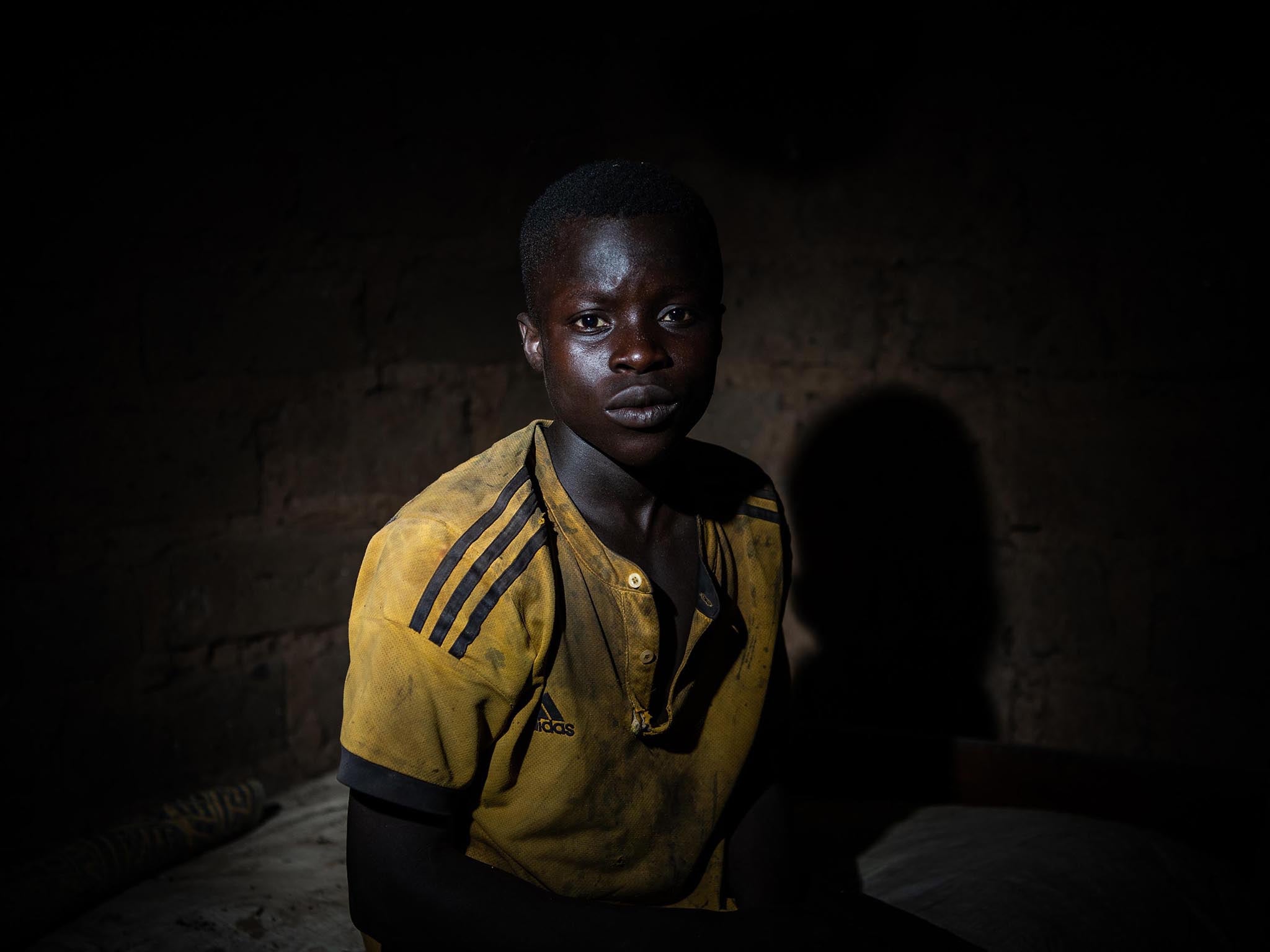 Karim Bakary, 16, from Burkina Faso, photographed inside a hut out in the woods near the cocoa farm where he works and sometimes takes shelter in with other children