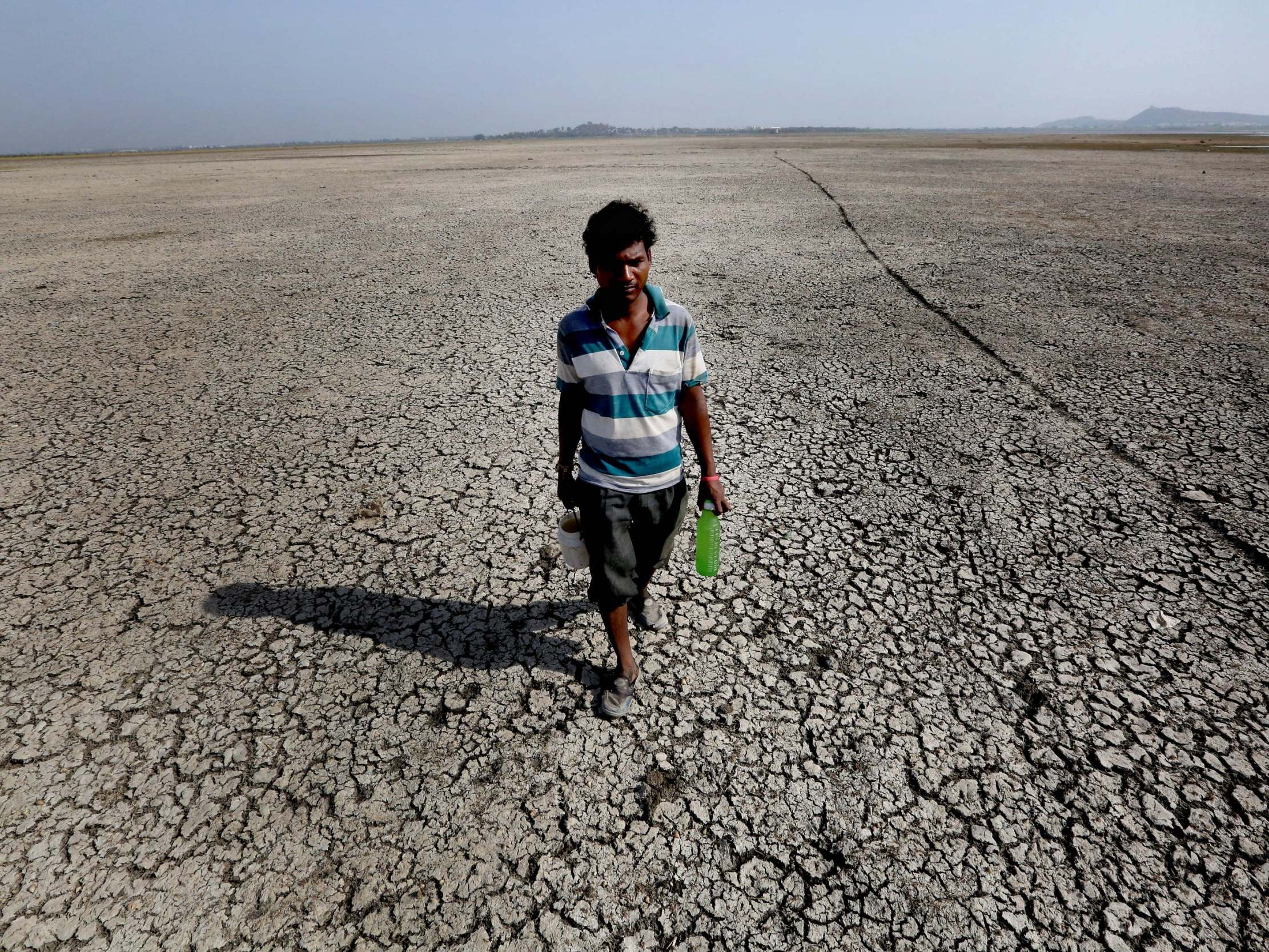 A man searching for drinking water walks on a dried-up portion of Asia's biggest lake, Upper Lake, after it shrunk during a heatwave in India.