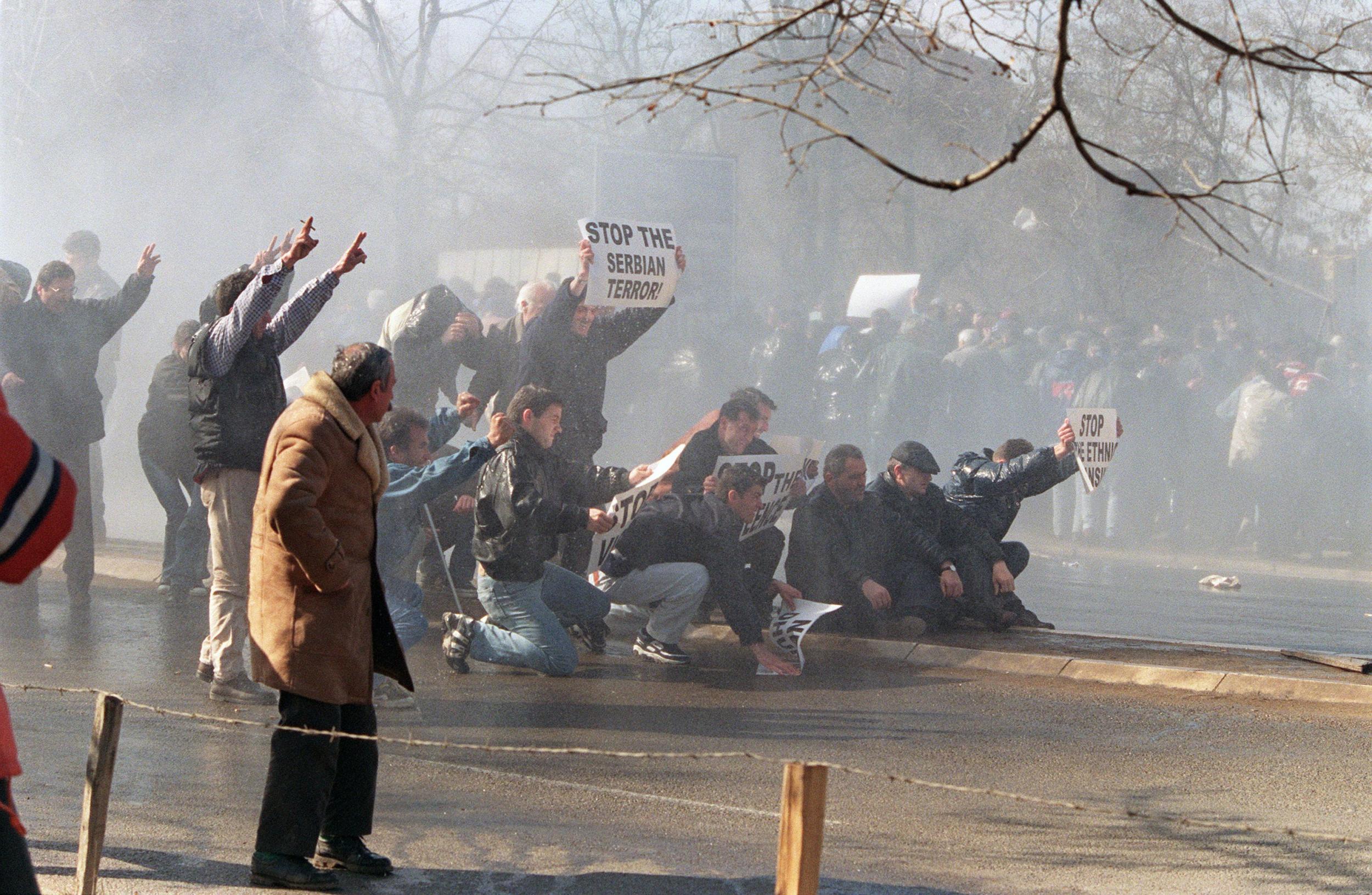 Ethnic Albanian demonstrators try to brave water canon used by Serbian riot police in Pristina in 1998 (AFP)