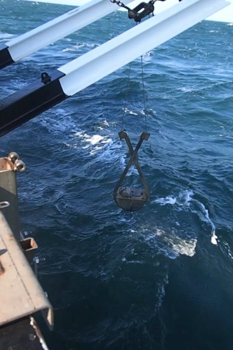 A grab bucket being lifted out of the sea after having been used to extract a sediment sample from the seabed. It was in just such sediment samples that the British and Belgian archaeologists, on the Belgian research vessel, found the two flint artefacts