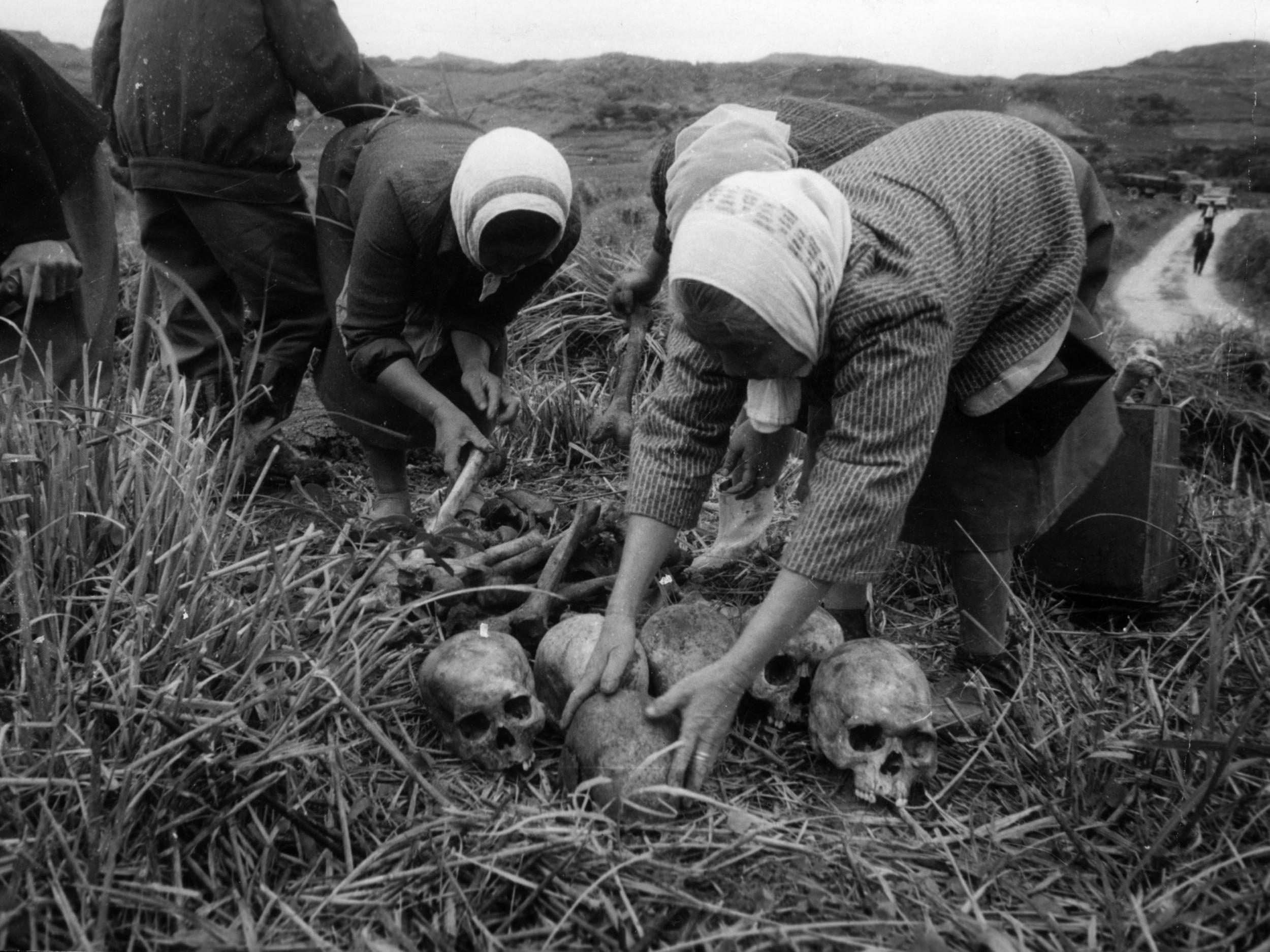 Okinawa women collect the remains of Japanese soldiers killed in the island during their battle with the US