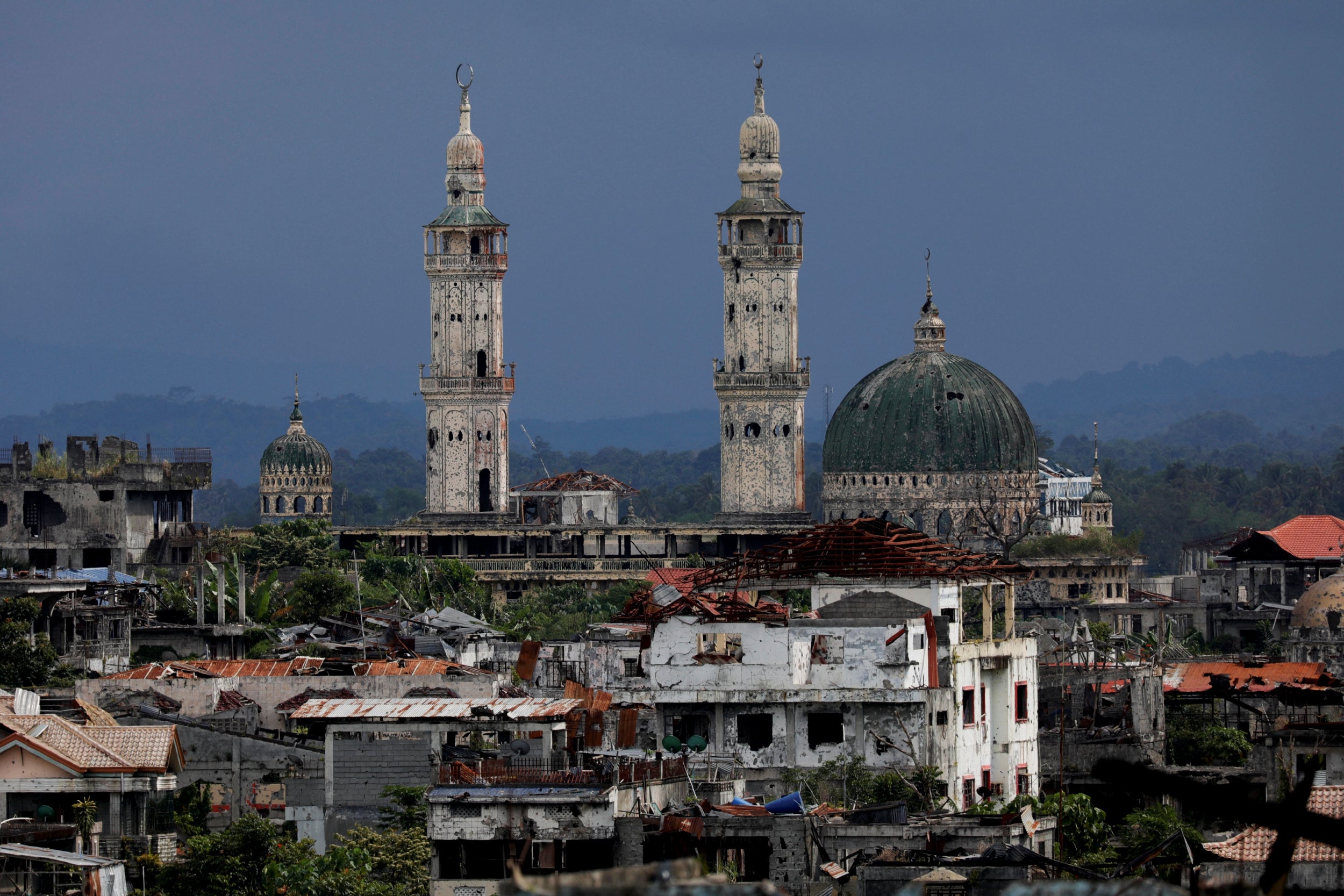 The Grand Mosque can be seen behind dilapidated buildings in the city
