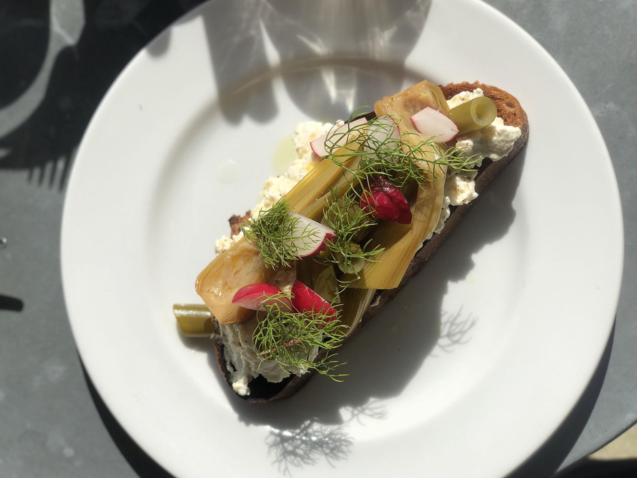 Toast with fluffy ricotta, confit wet garlic, honey and radish