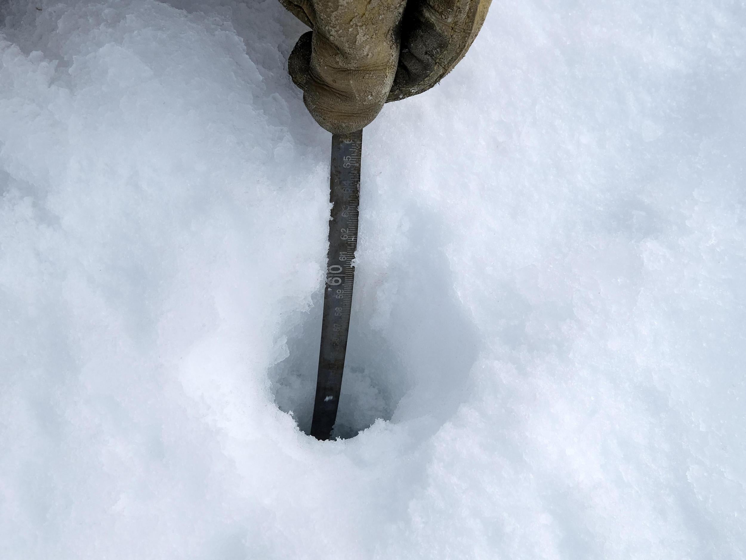 Researchers measure depths through an ice core hole